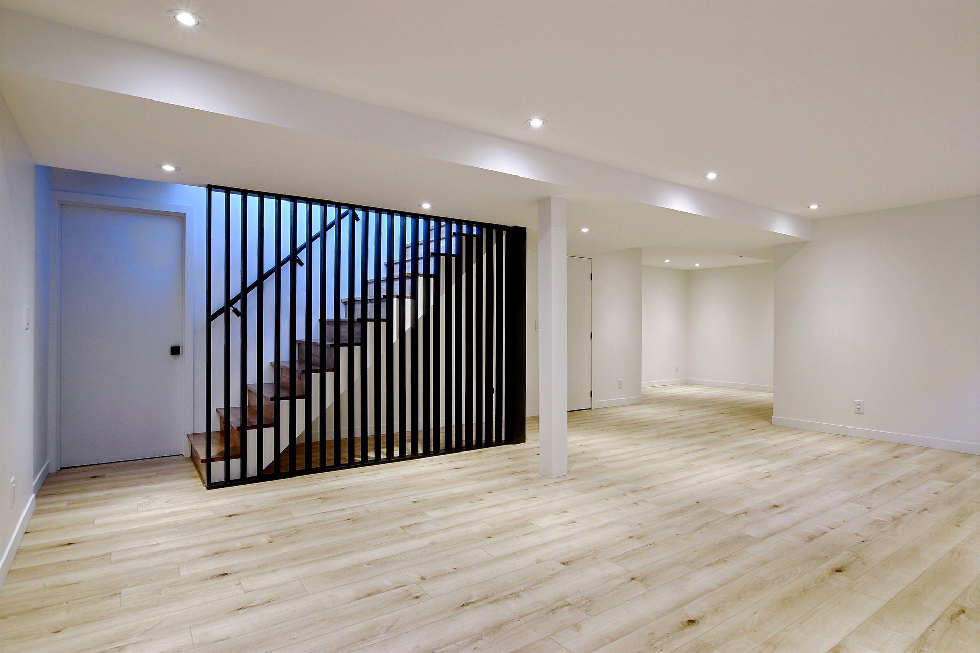 Un sous-sol vide avec parquet et escaliers en bois