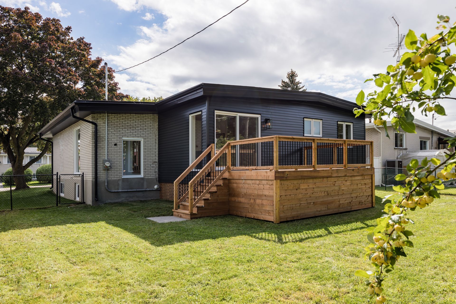 L'arrière d'une maison avec une terrasse en bois et des escaliers.