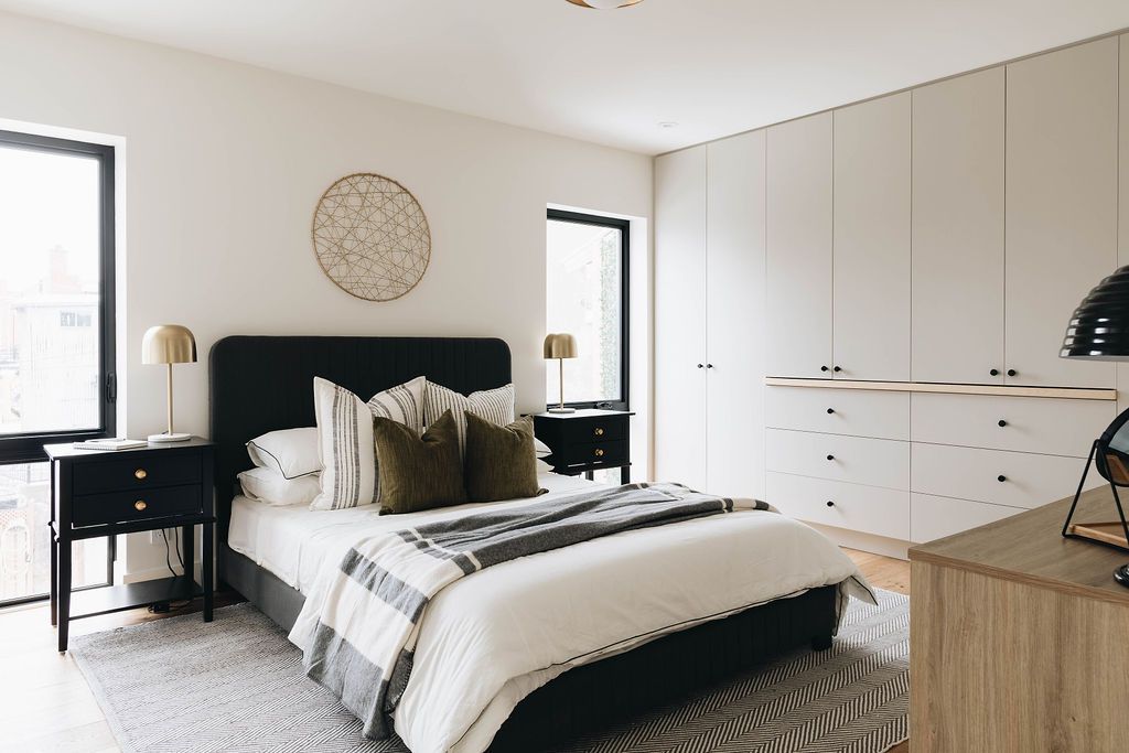 Une chambre avec un lit, une table de nuit, une commode et une fenêtre.