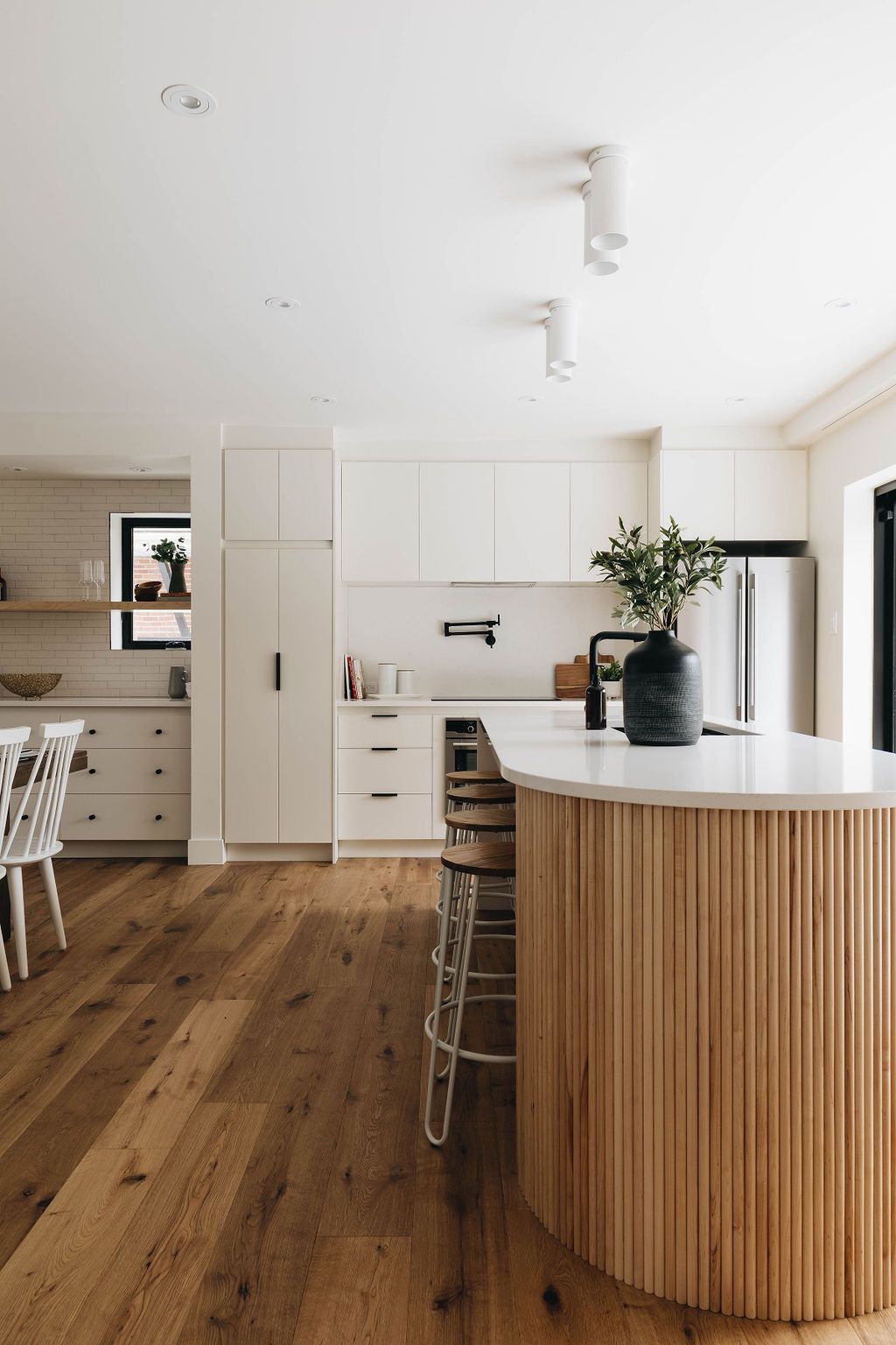 Une cuisine avec un îlot en bois et des armoires blanches.