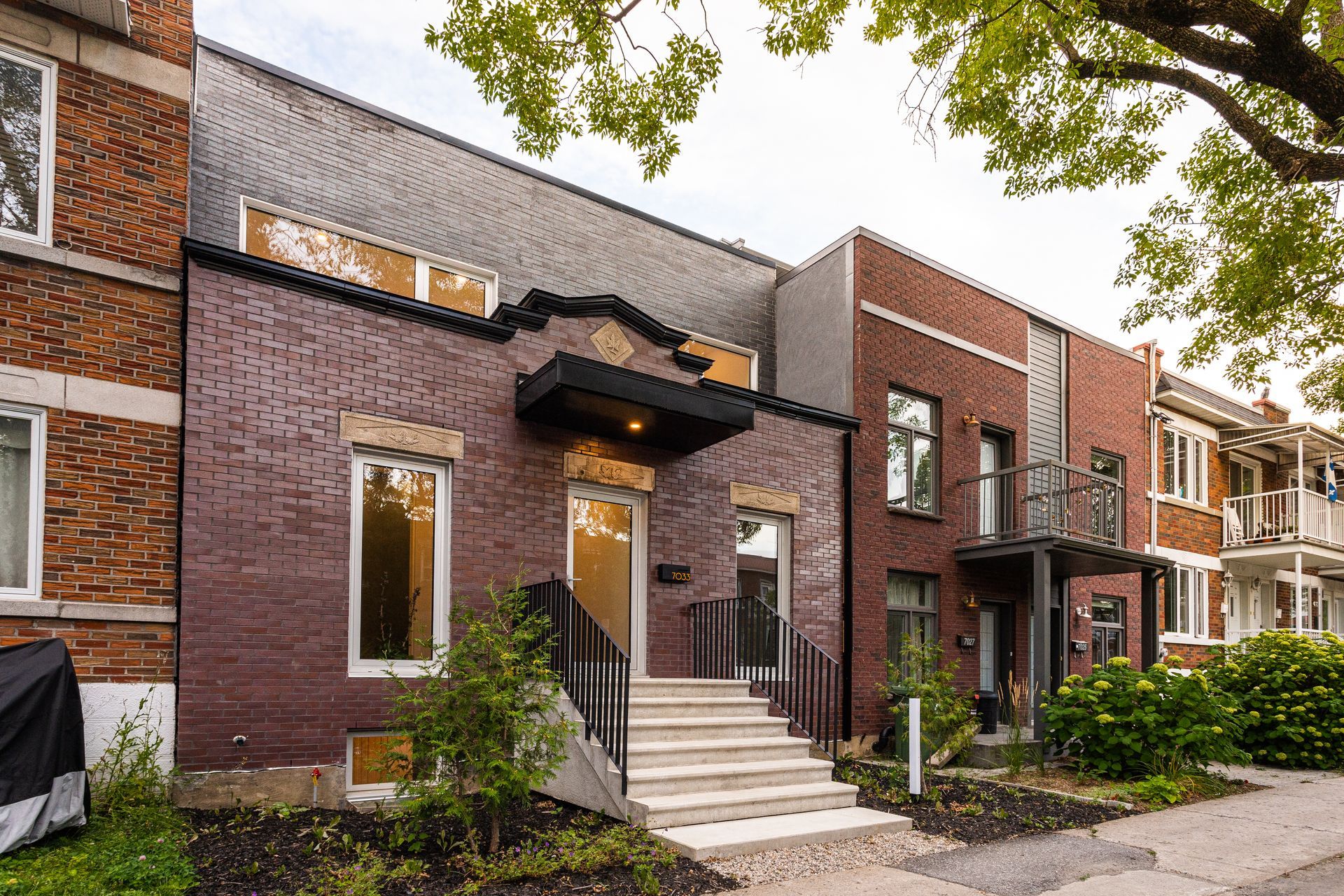 Une rangée de bâtiments en briques avec des escaliers menant à la porte d'entrée.