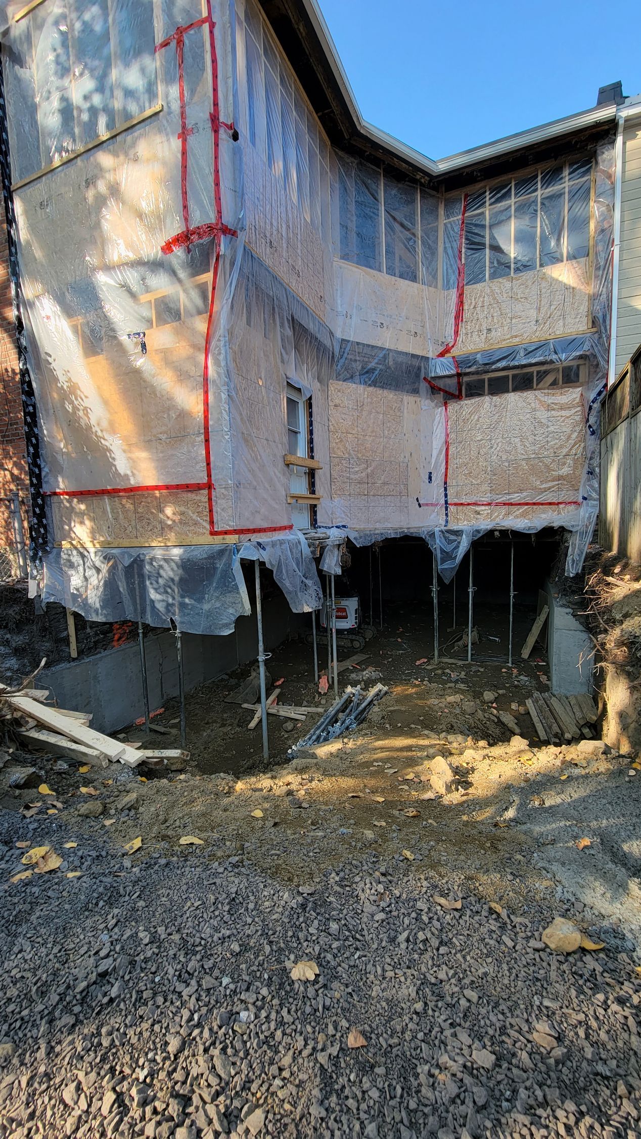 Une grande maison est en train d'être construite au sommet d'un champ de terre.