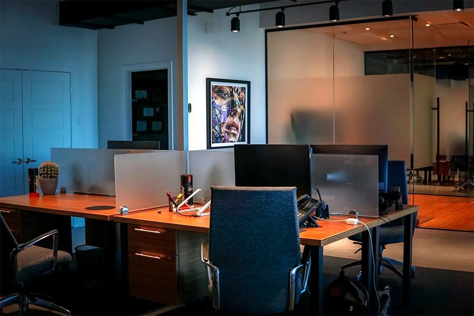 Une rangée de bureaux avec des ordinateurs et des chaises dans un bureau.