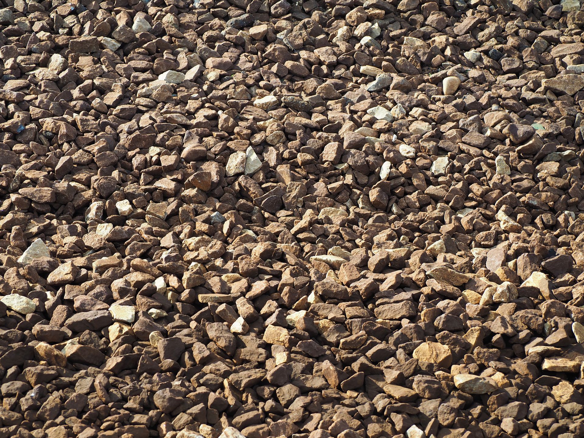 Fondations endommagées du porche d'une maison blanche, laissant apparaître le béton qui s'effrite et la terre à nu.