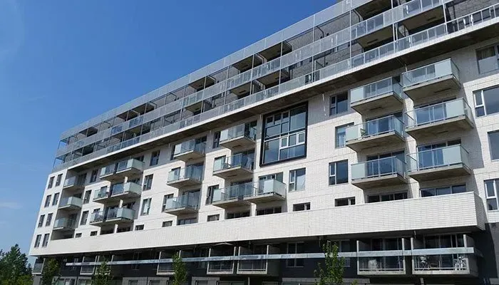 Un grand immeuble d'appartements avec beaucoup de fenêtres et de balcons.