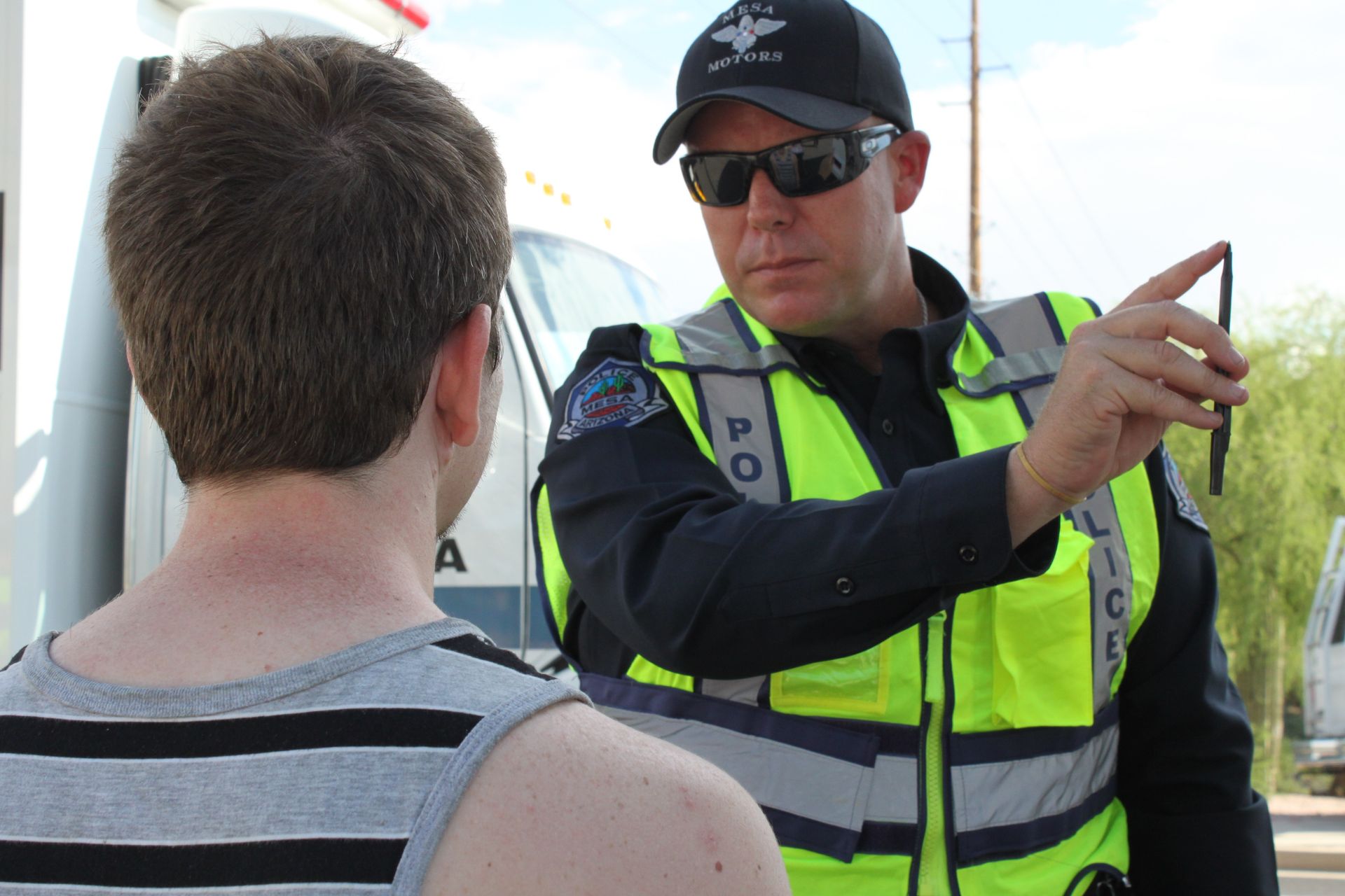 a police officer talking to a young man wearing sunglasses