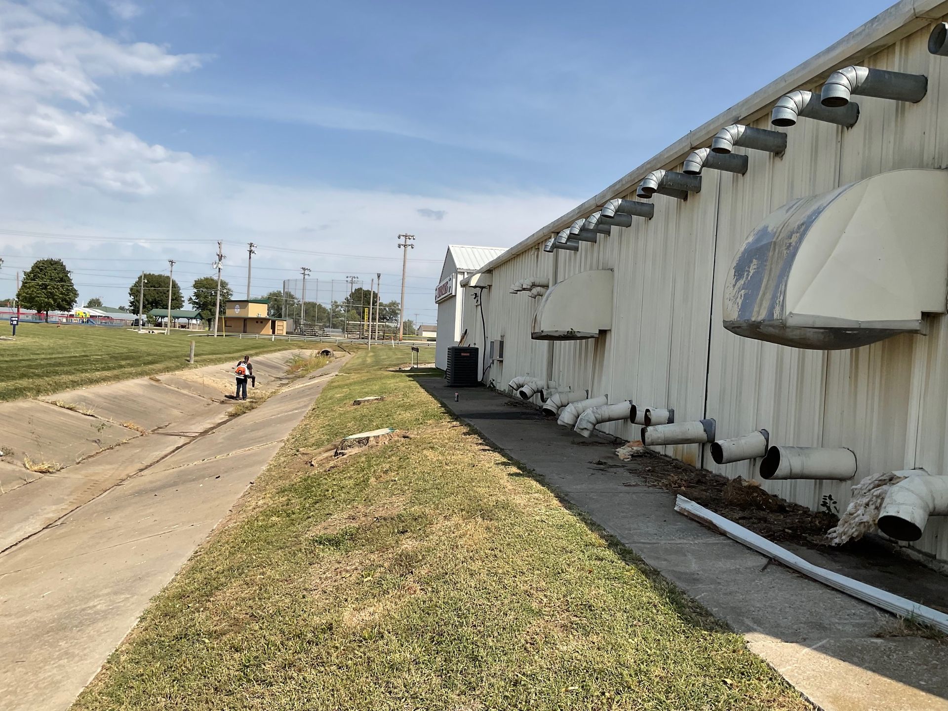 A white building with a lot of pipes on the side of it.
