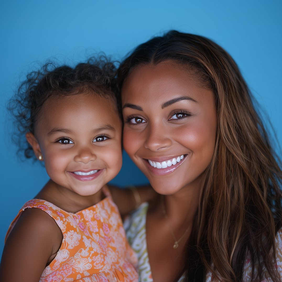 Woman and child smiling, embracing in front of a blue background.