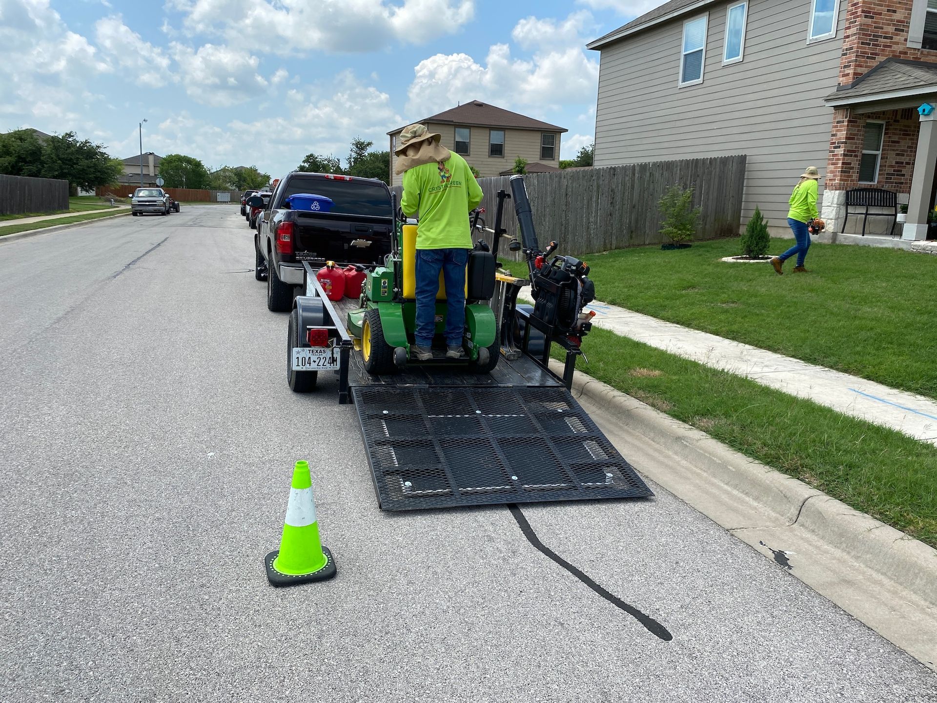a man is standing next to a lawn mower on a trailer .