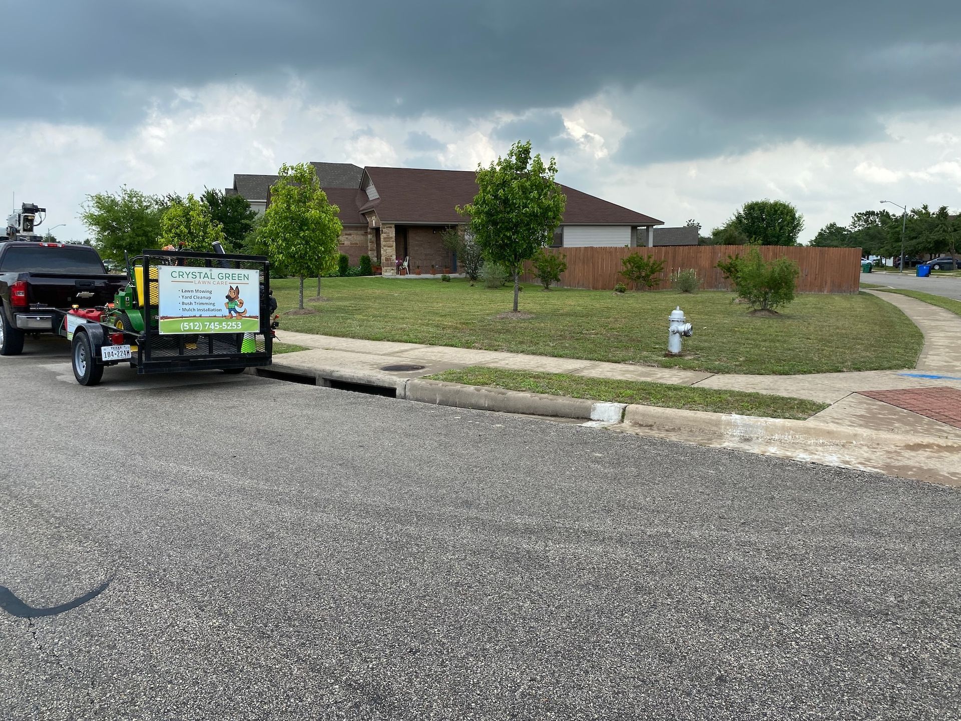A trailer is parked on the side of the road next to a house.