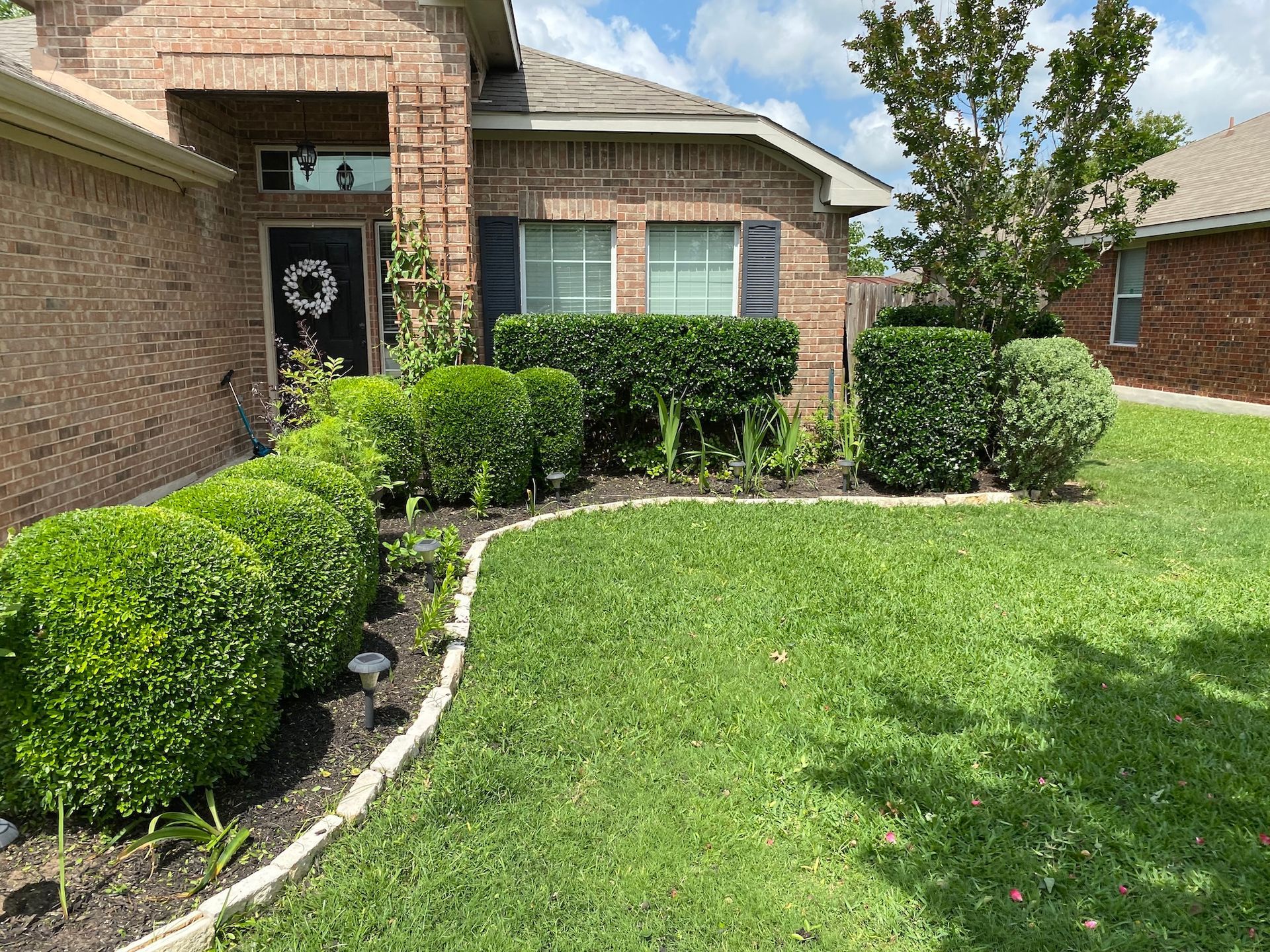 a brick house with a lush green lawn in front of it .