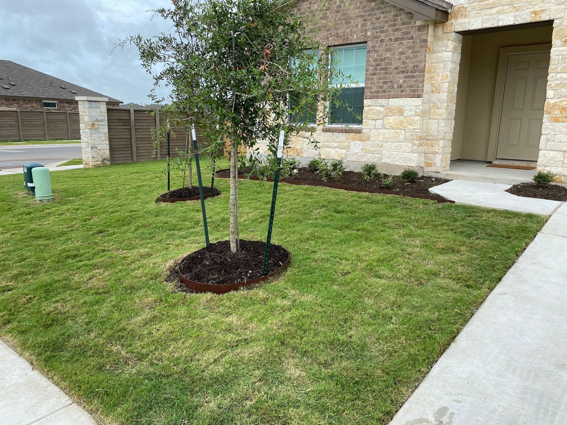 a house with a lush green lawn and trees in front of it .