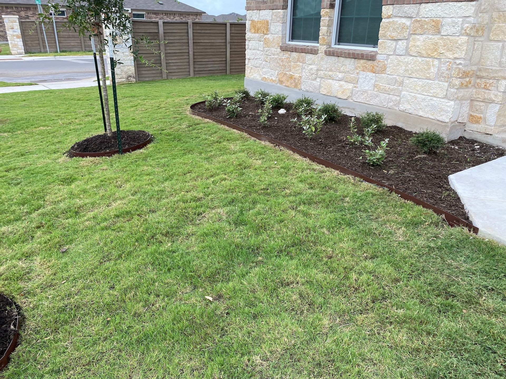 a lush green lawn with a stone house in the background .