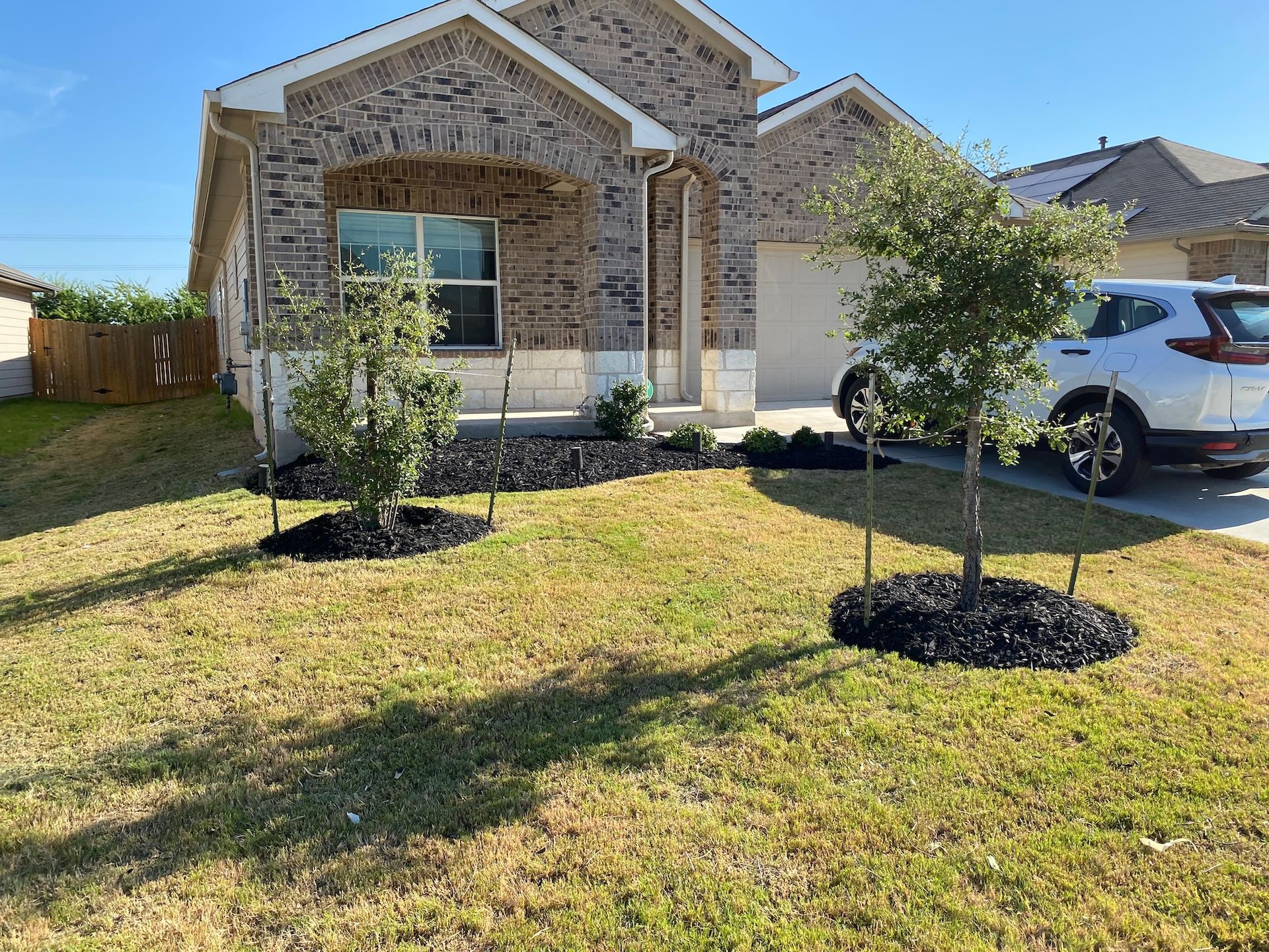 a white car is parked in front of a brick house .
