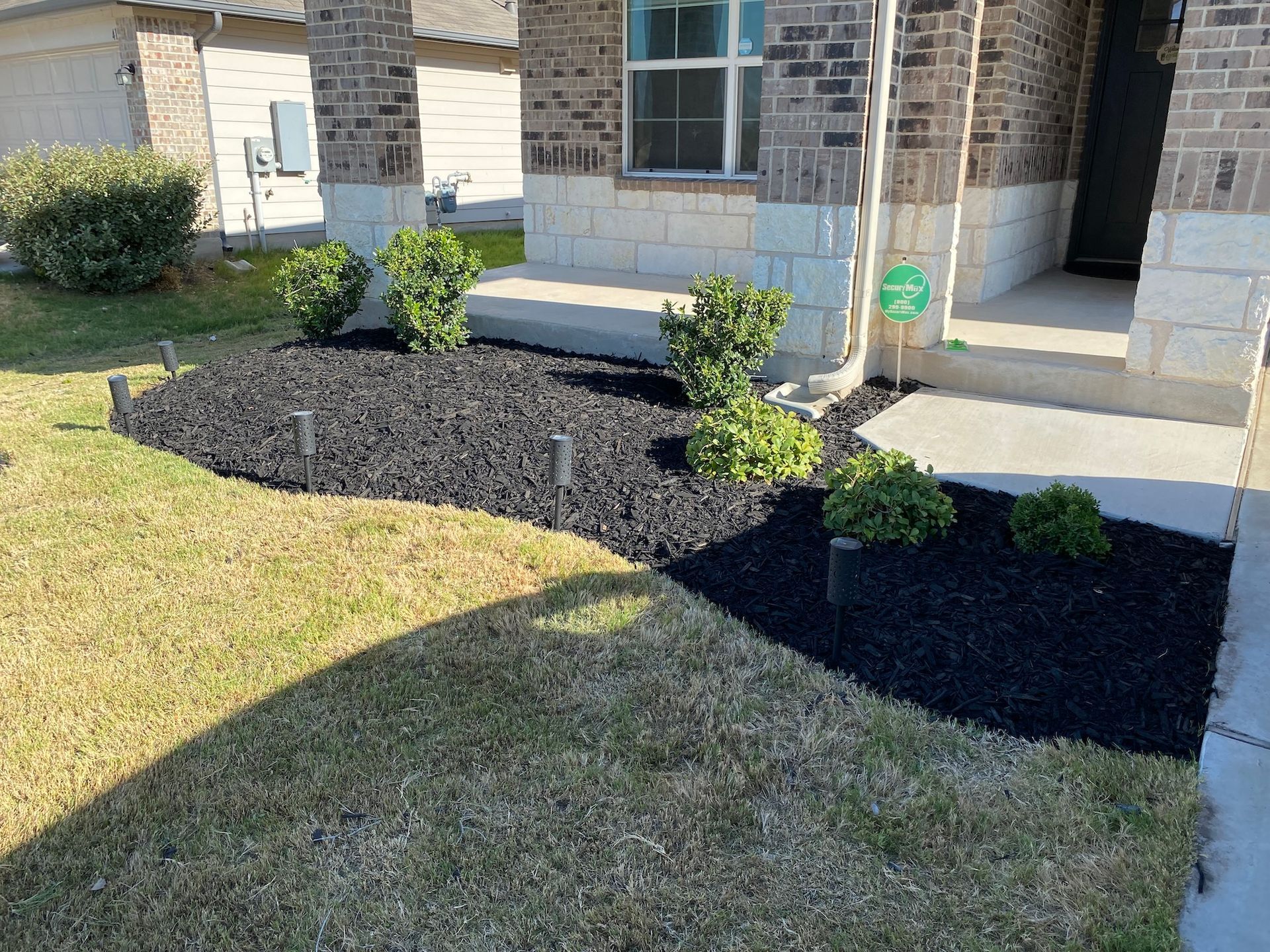 a house with a lot of black mulch in front of it .