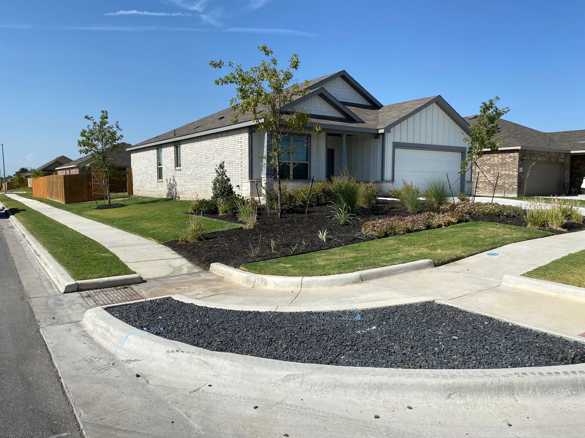 a house is sitting on the corner of a street next to a sidewalk .