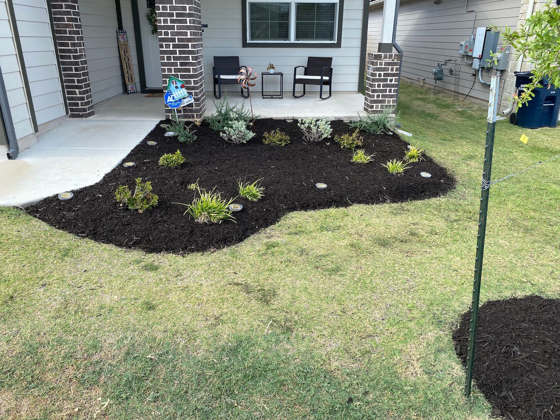 a front yard of a house with a lush green lawn and a porch .