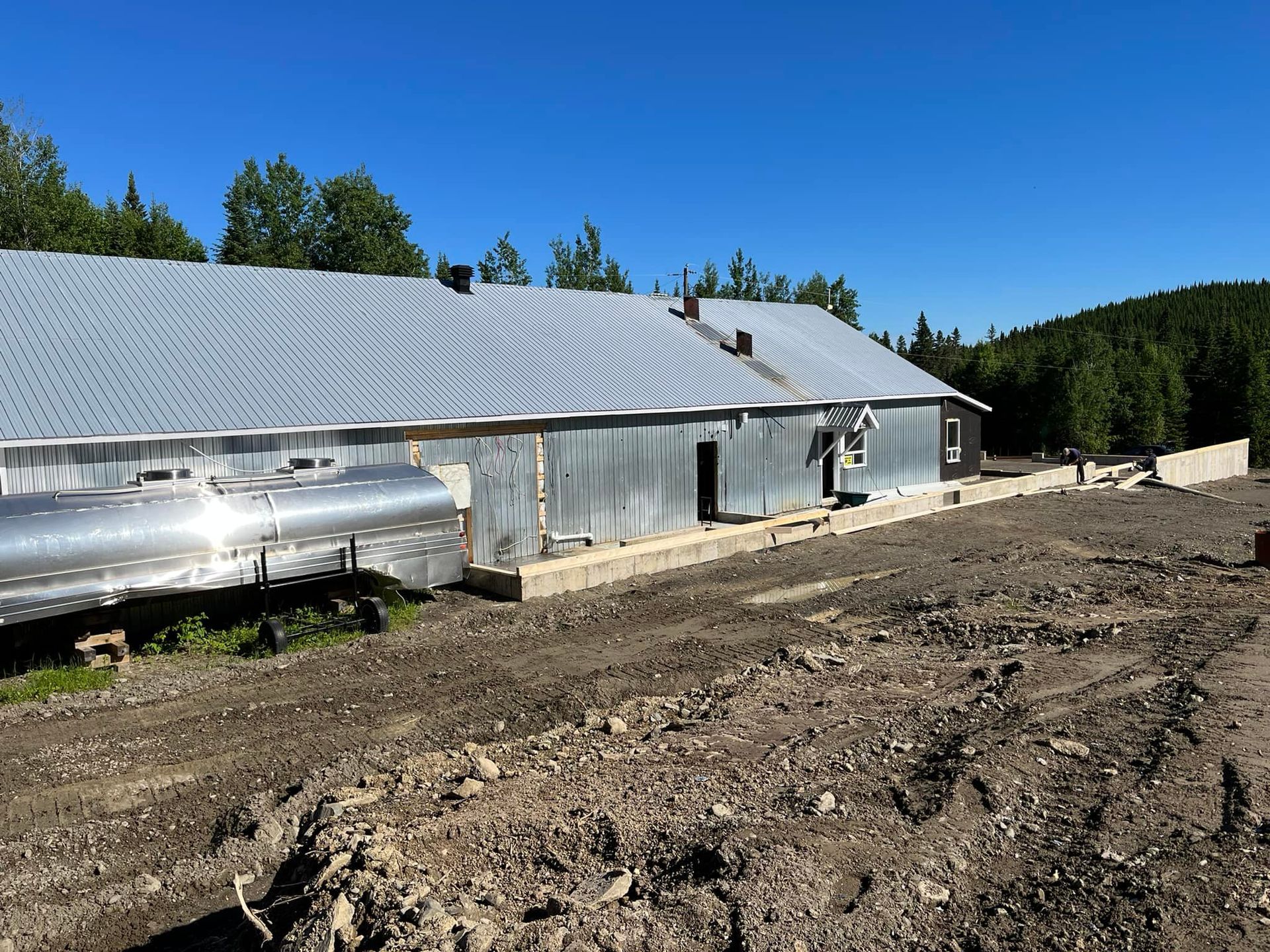 Un grand bâtiment métallique avec un tuyau devant lui