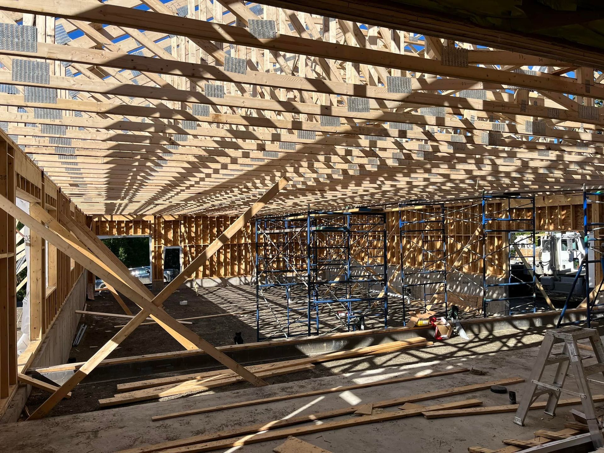 L'intérieur d'un bâtiment en construction avec beaucoup de poutres en bois.