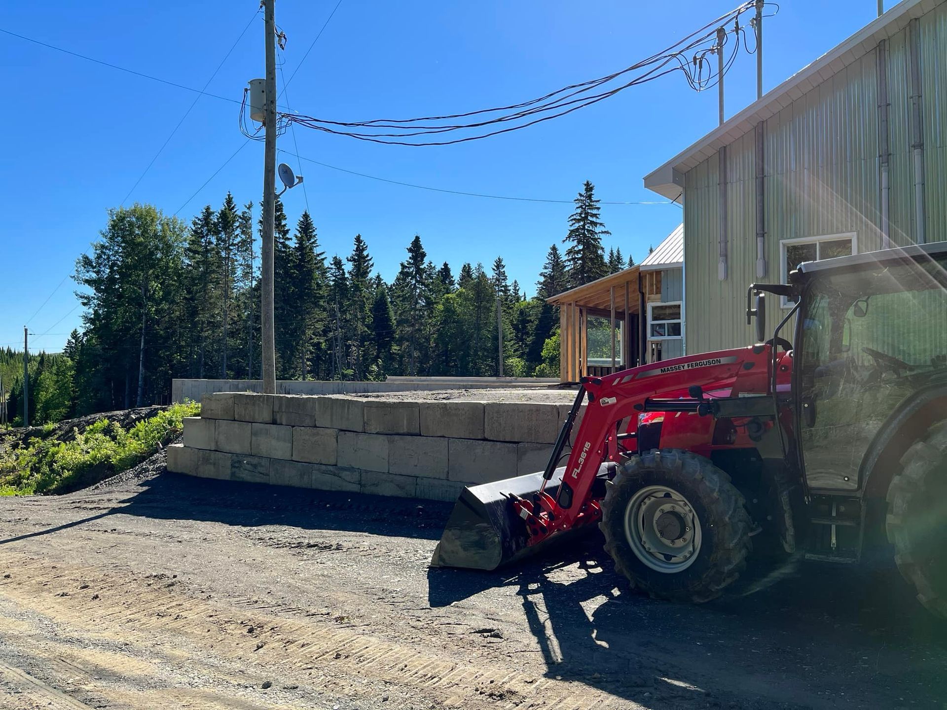 Un tracteur rouge est garé devant un bâtiment.