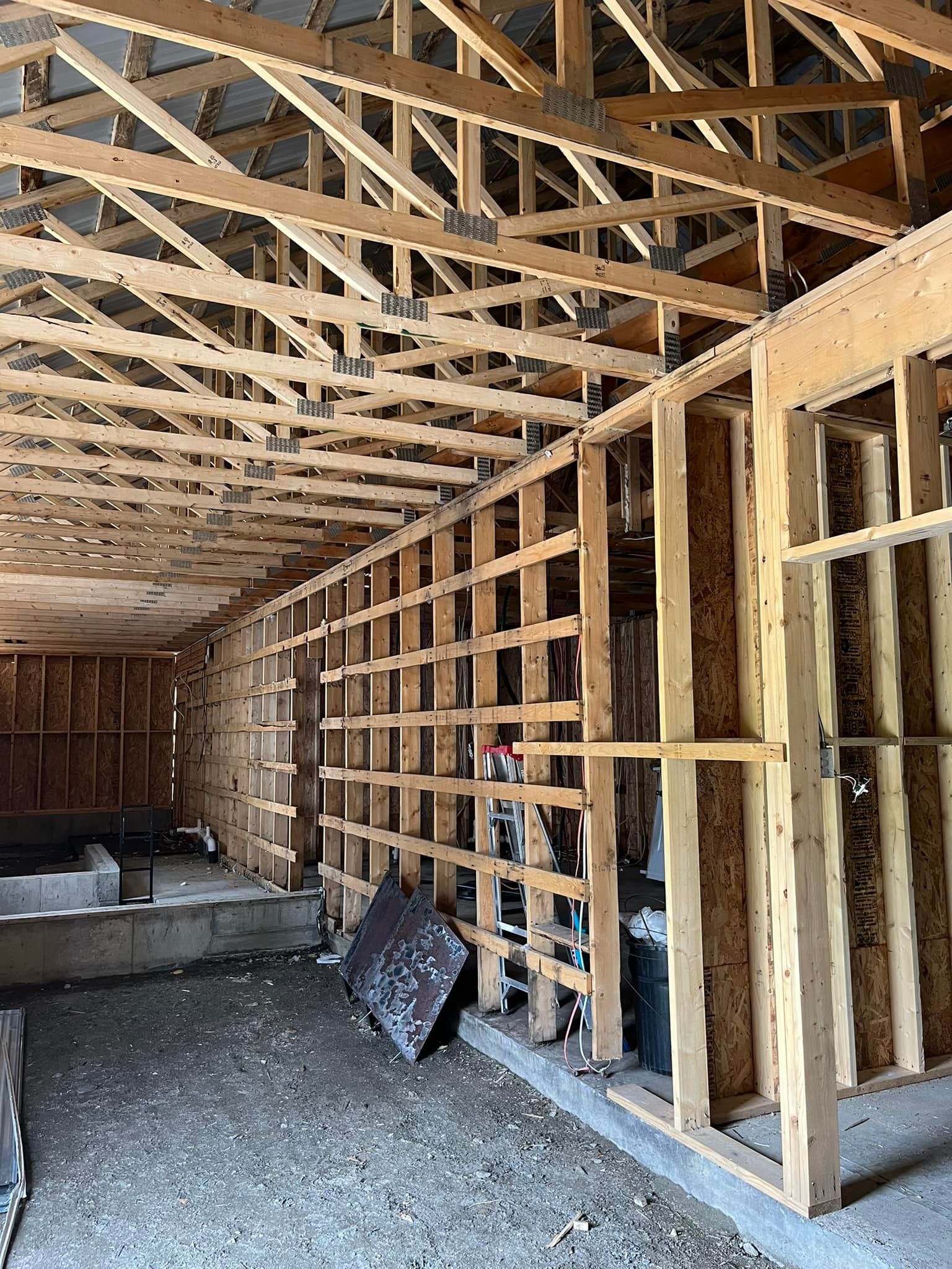 L'intérieur d'un bâtiment en construction avec beaucoup de poutres en bois.
