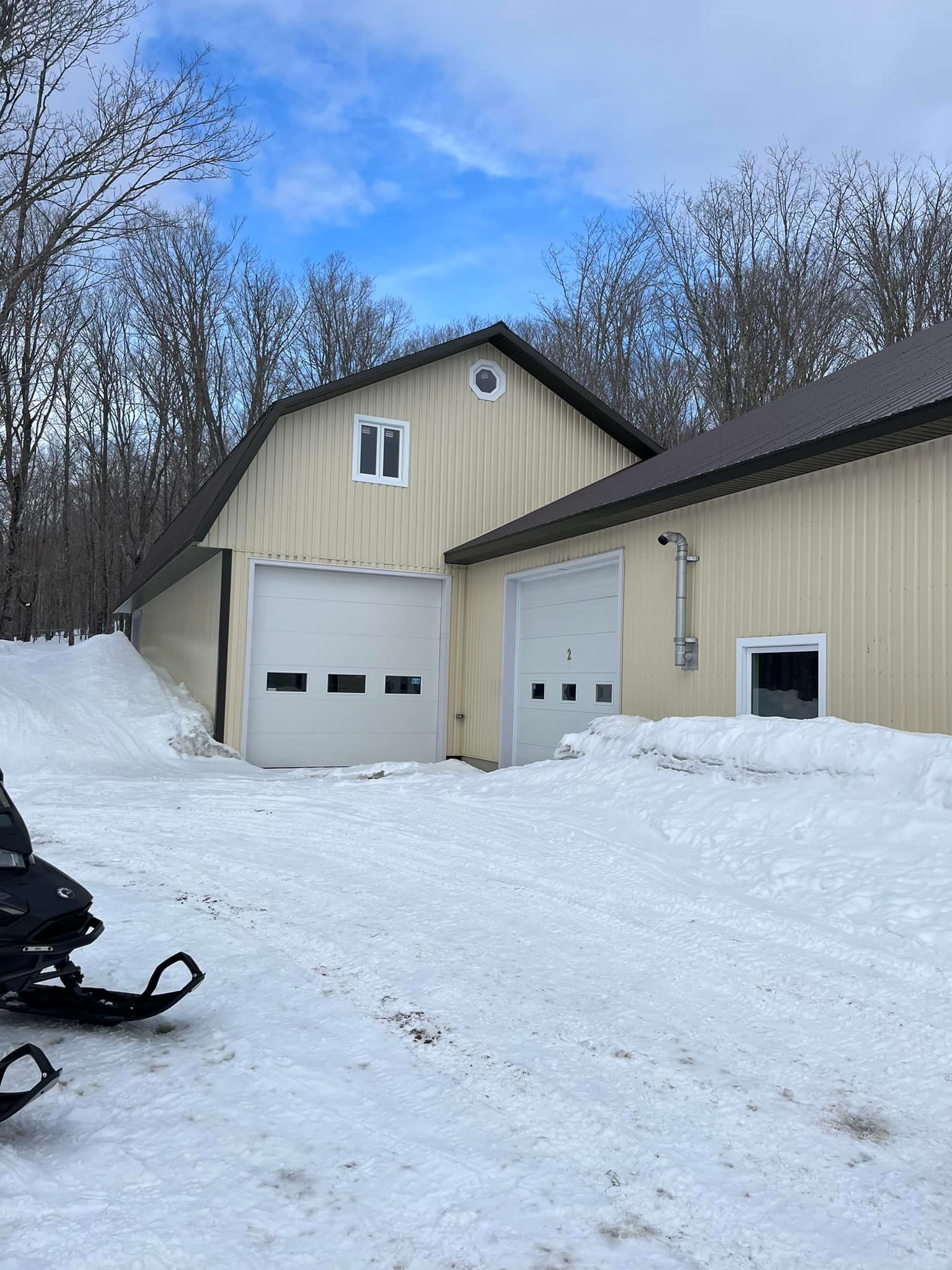 Une motoneige est garée devant un bâtiment dans la neige.