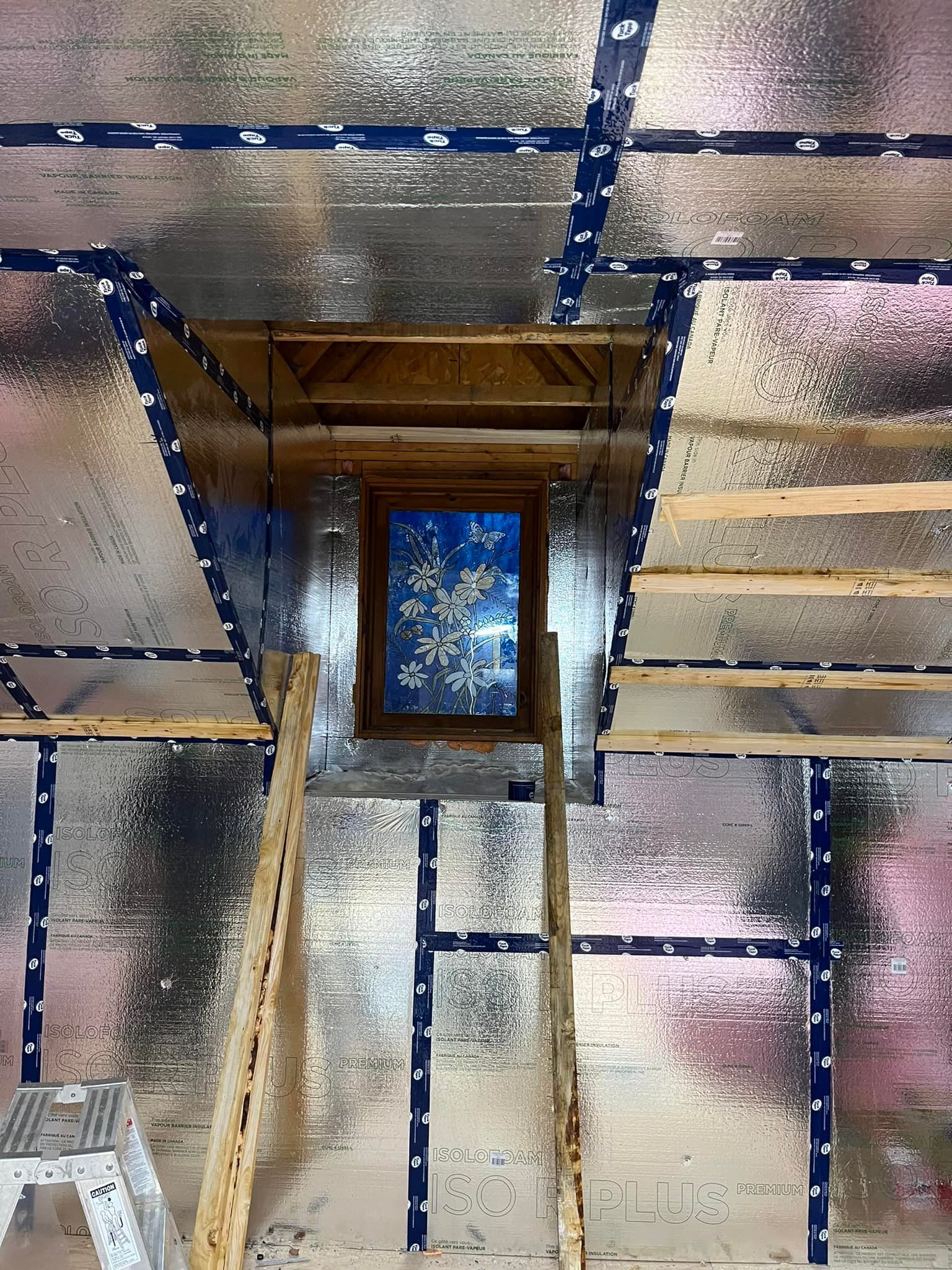 Une pièce avec une échelle et une fenêtre au plafond.