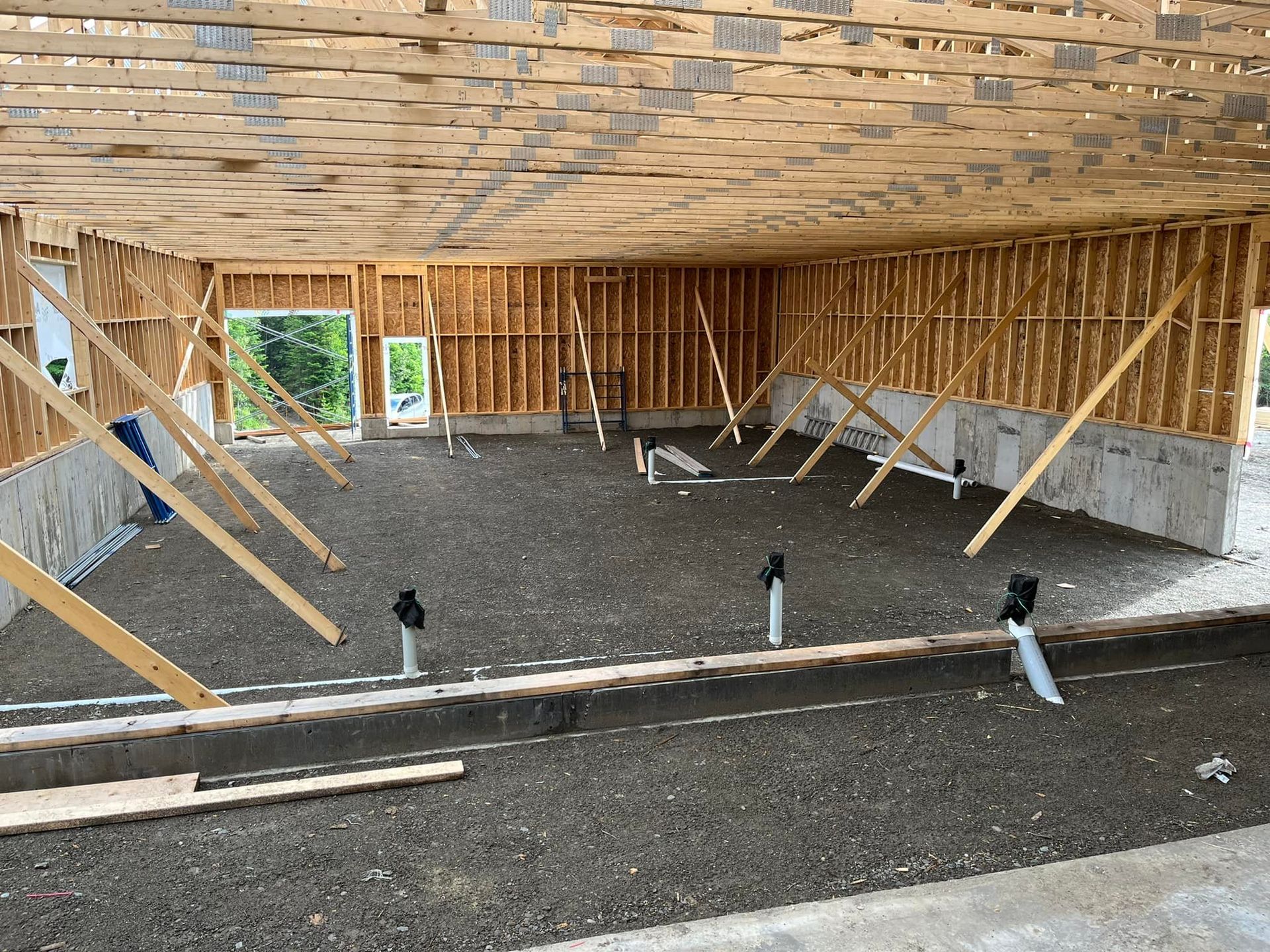 L'intérieur d'un bâtiment en construction avec beaucoup de poutres en bois.