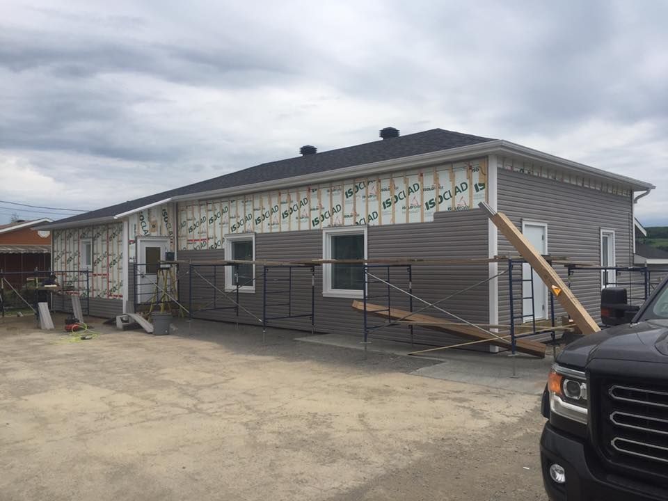 Un camion est garé devant une maison en construction.