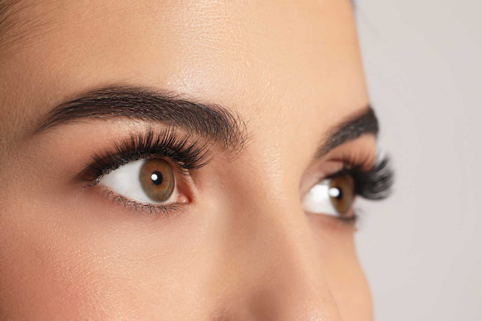 Close-up of brown eyes with dark lashes and well-defined eyebrows.