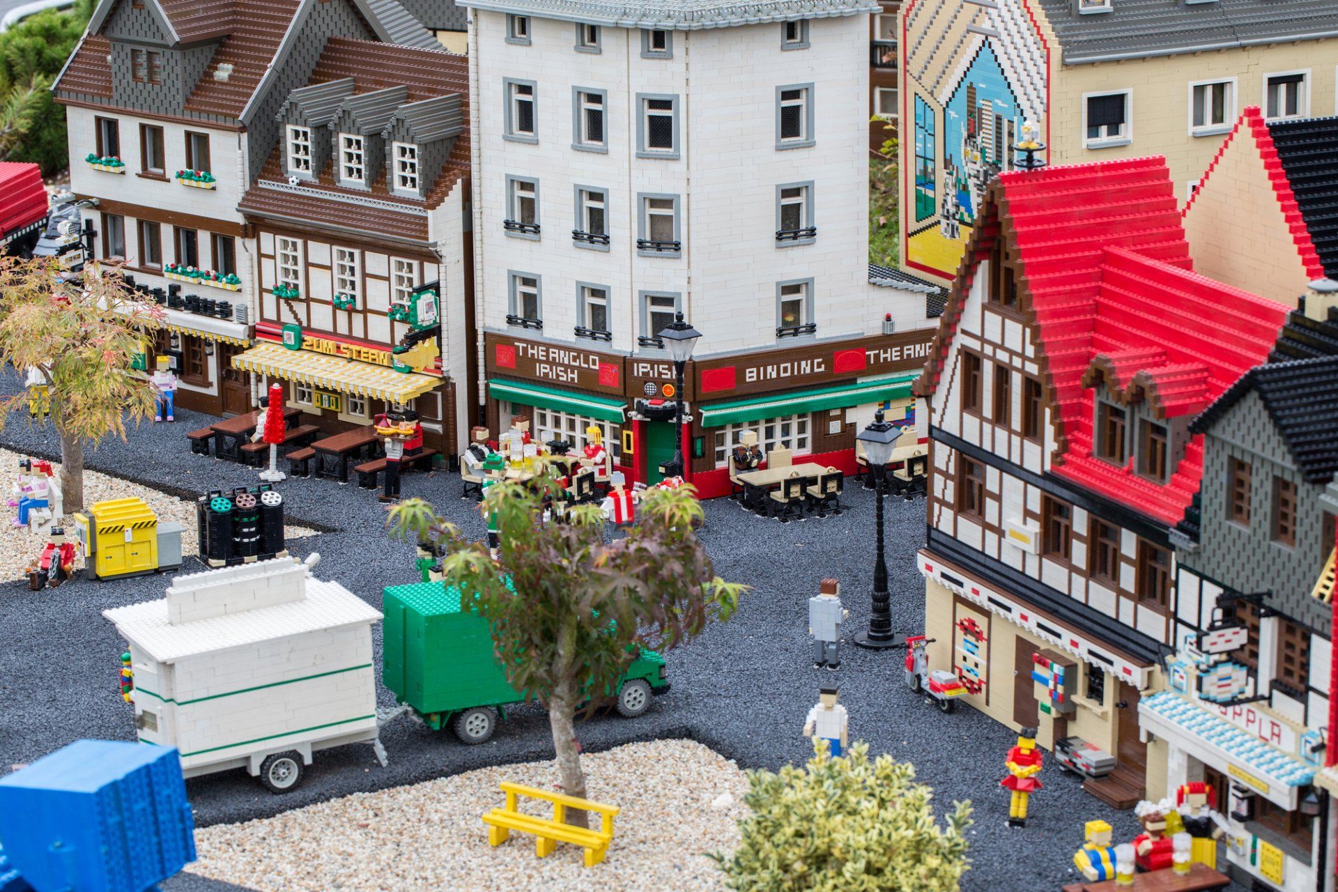 Lego town scene featuring buildings with colorful facades, minifigures, and vehicles.