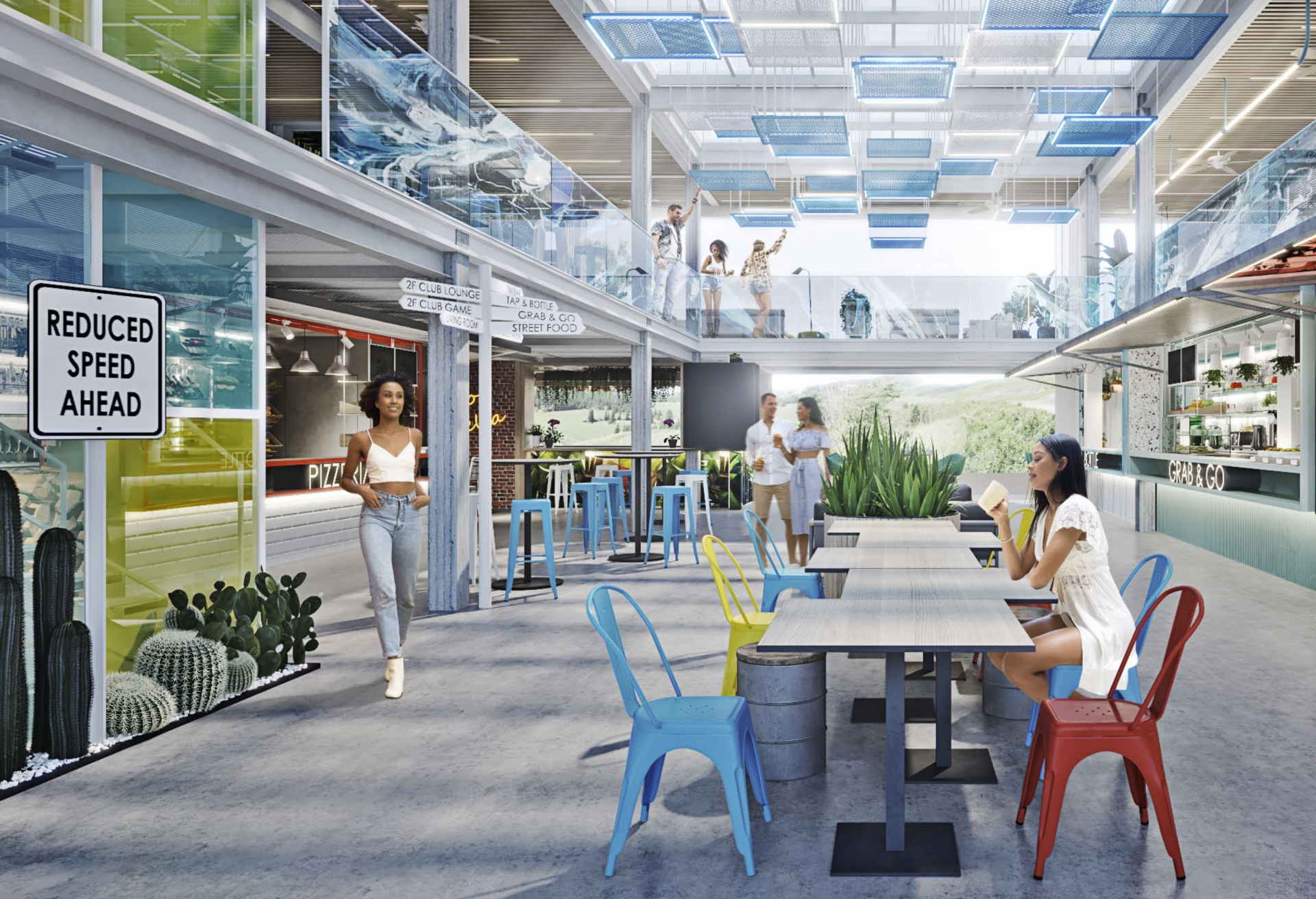 People in a colorful indoor/outdoor space with tables and chairs, including a sign that reads 