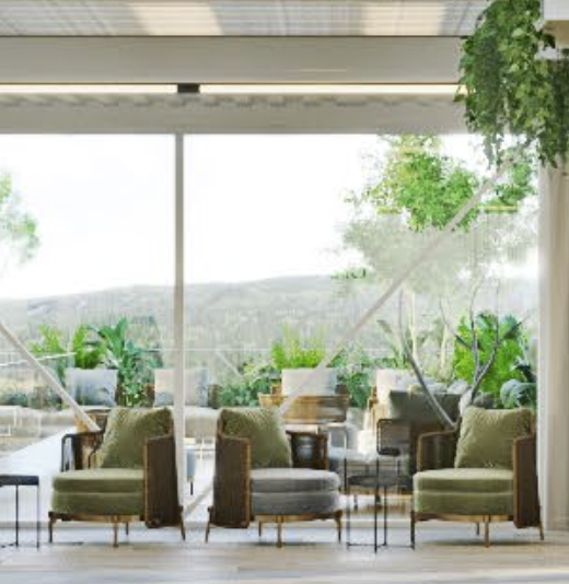 Three armchairs with green cushions in a light-filled space, overlooking a natural landscape through large windows.
