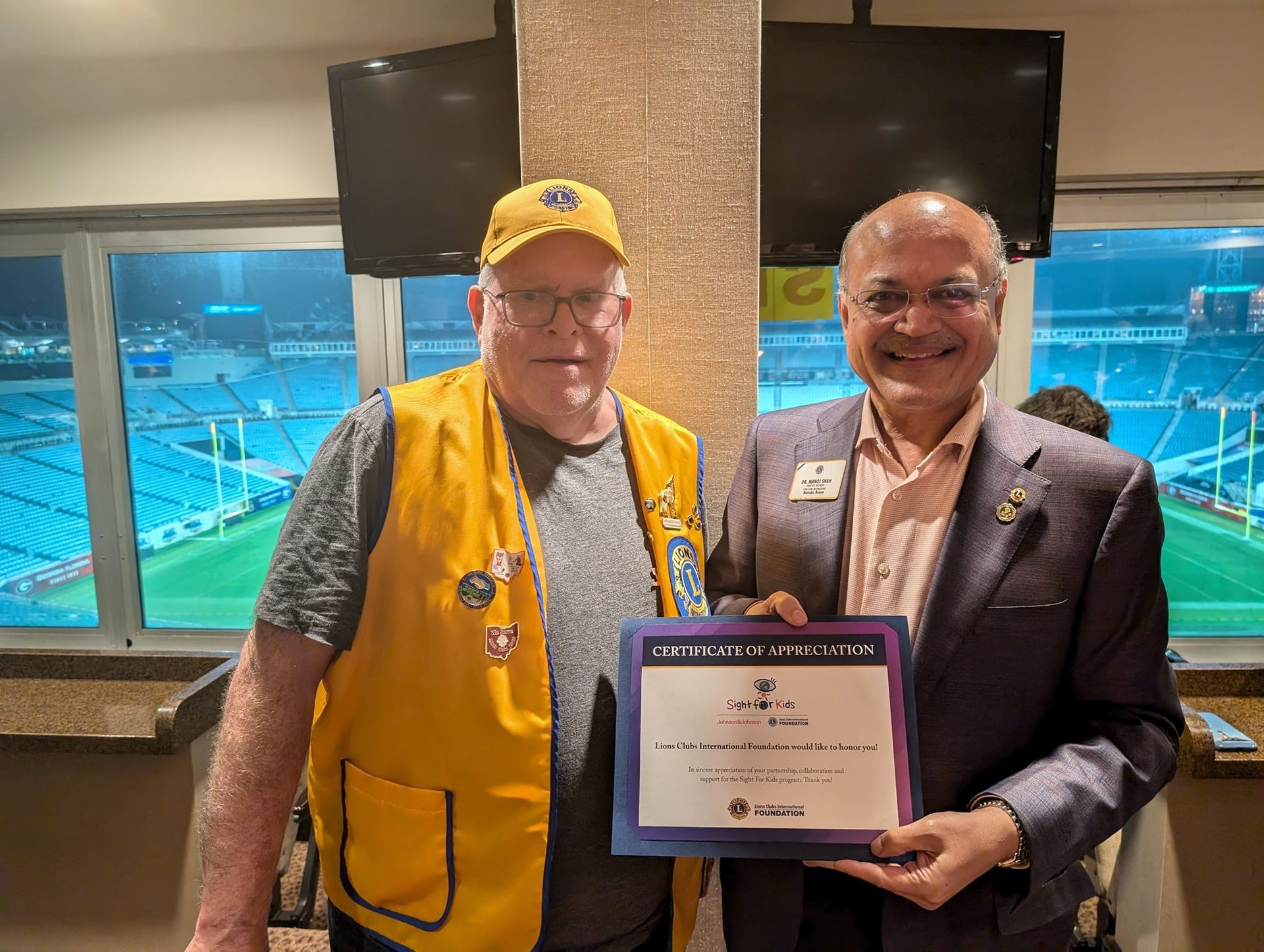 Two men are standing next to each other holding a certificate.