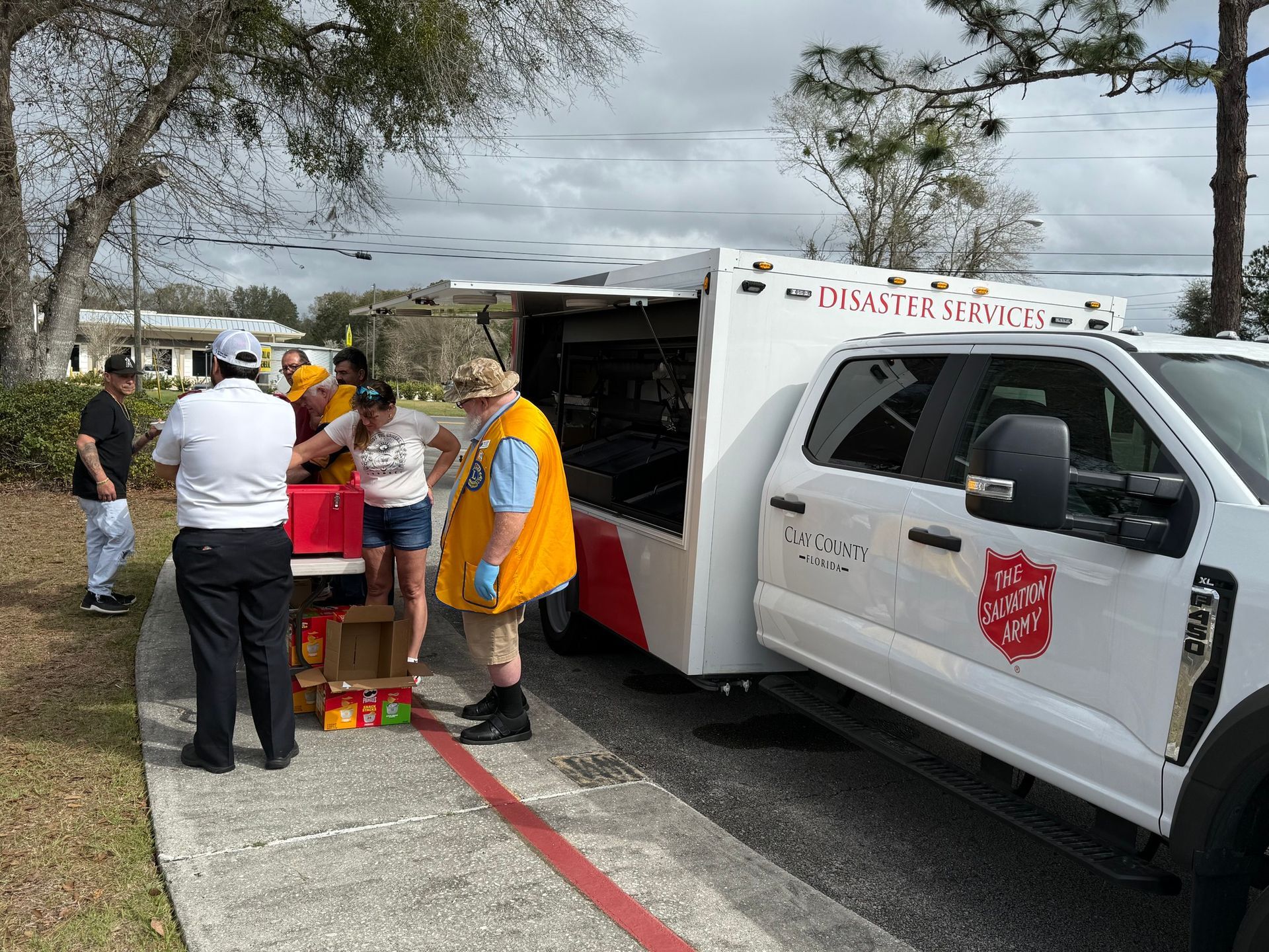A group of people are standing next to a white truck.