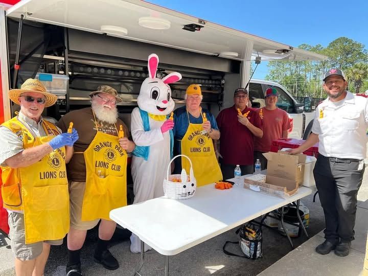 A group of people standing around a table with a bunny mascot.