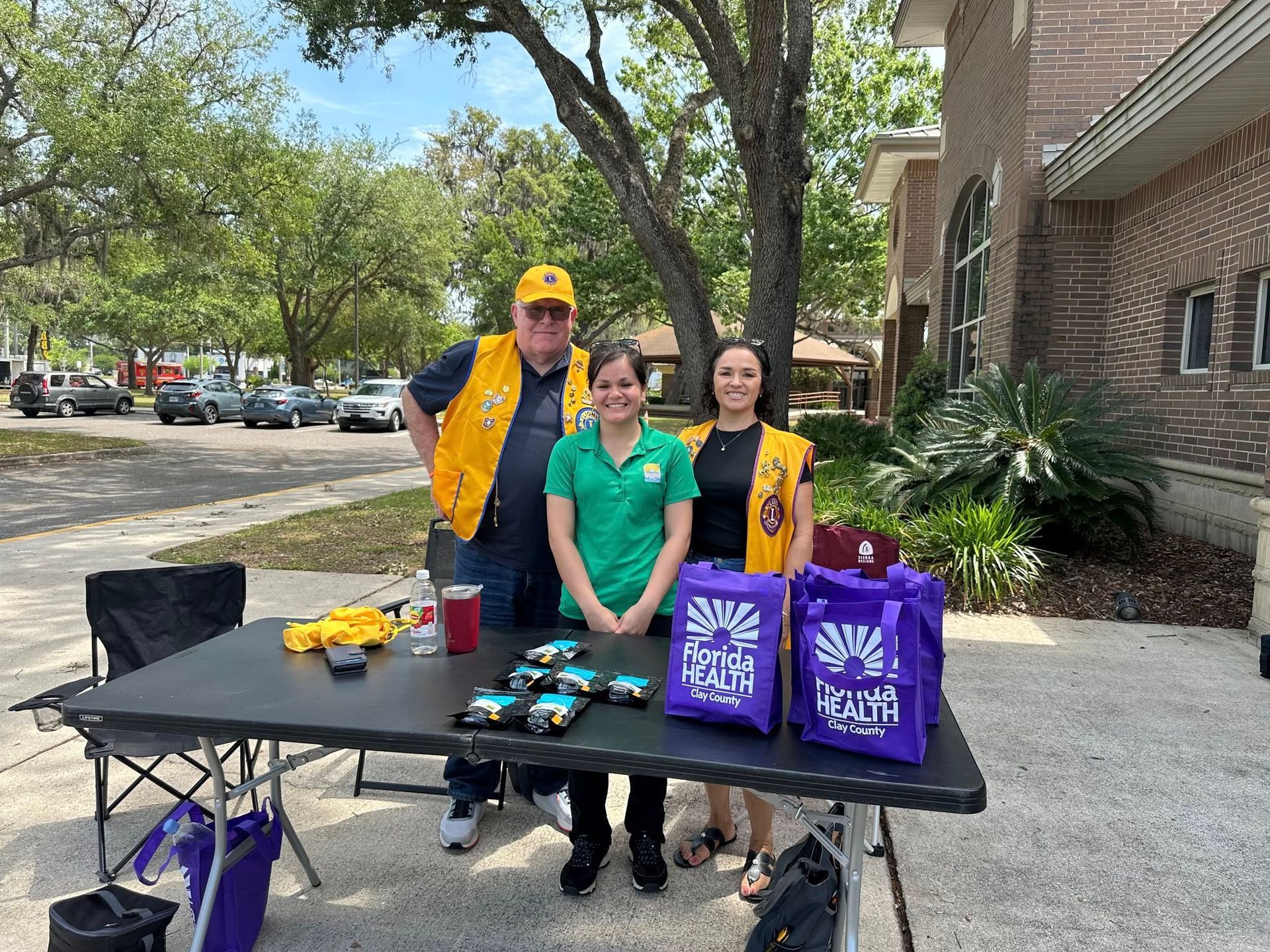 A group of people standing around a table with purple bags.