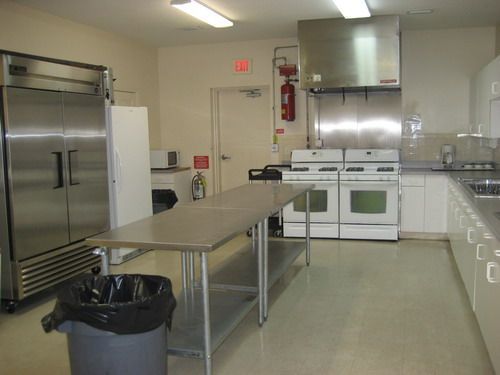 A kitchen with stainless steel appliances and a trash can