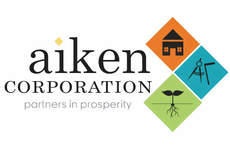 Aiken Corporation logo with tagline supporting local economic development