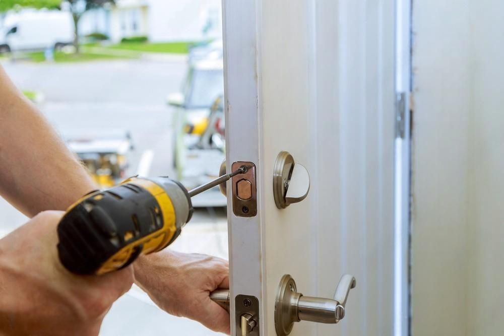 A person is fixing a door with a drill.