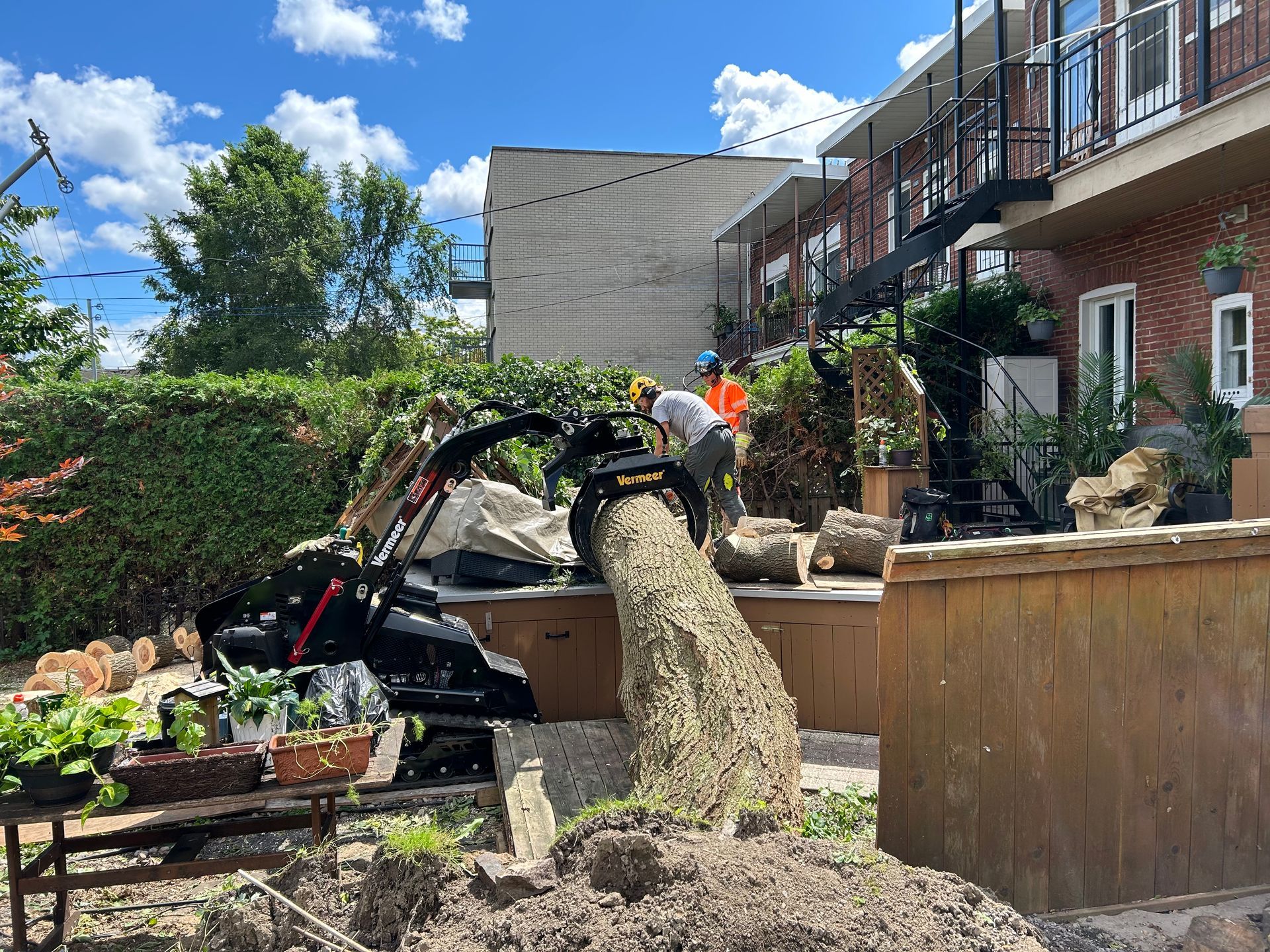 Un homme se tient à côté d'un gros tas de terre devant un bâtiment.