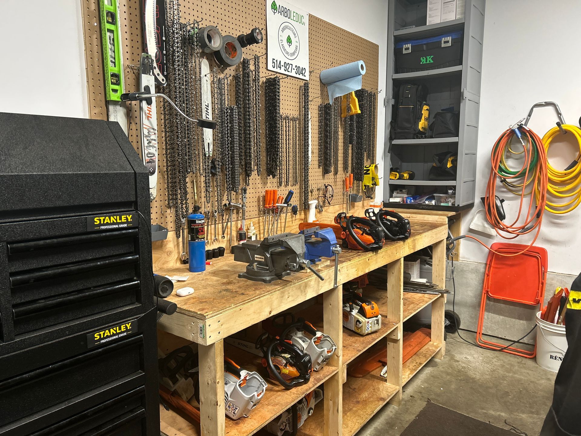 Un garage rempli de nombreux outils et d'un établi en bois.