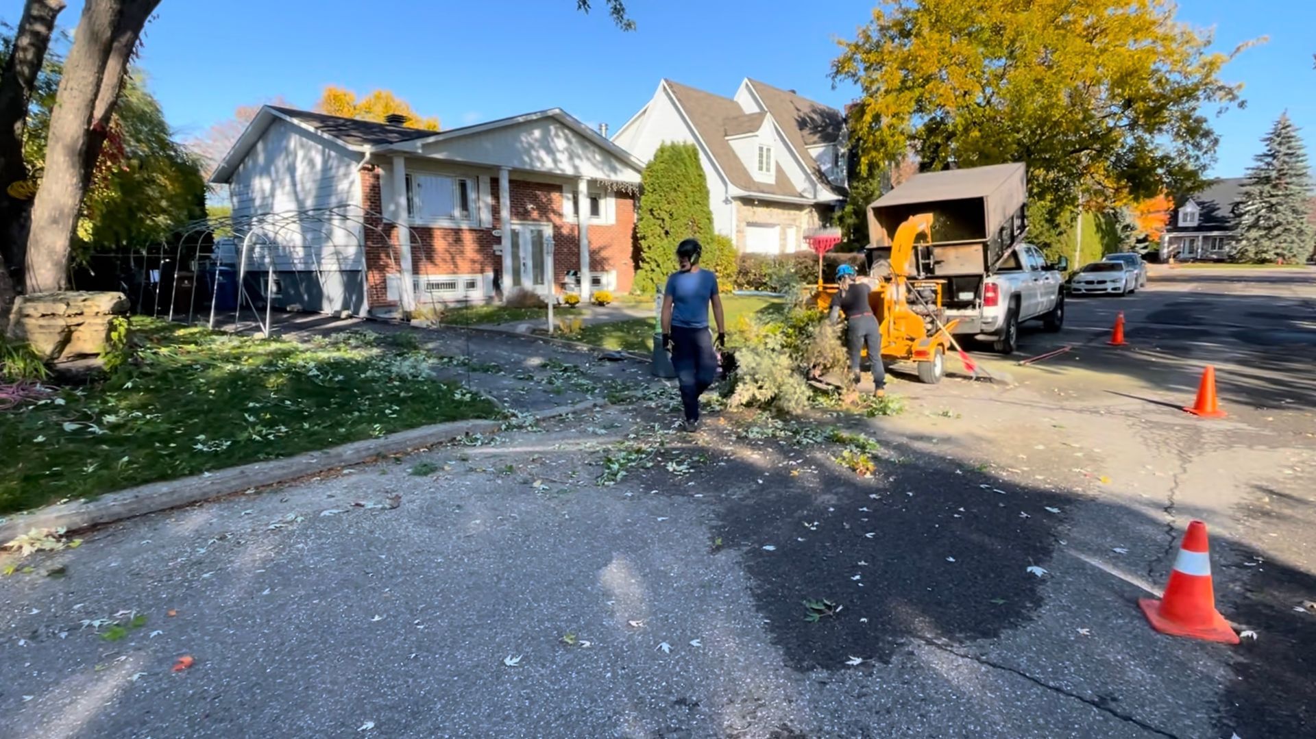 Un homme marche dans une rue devant une maison.