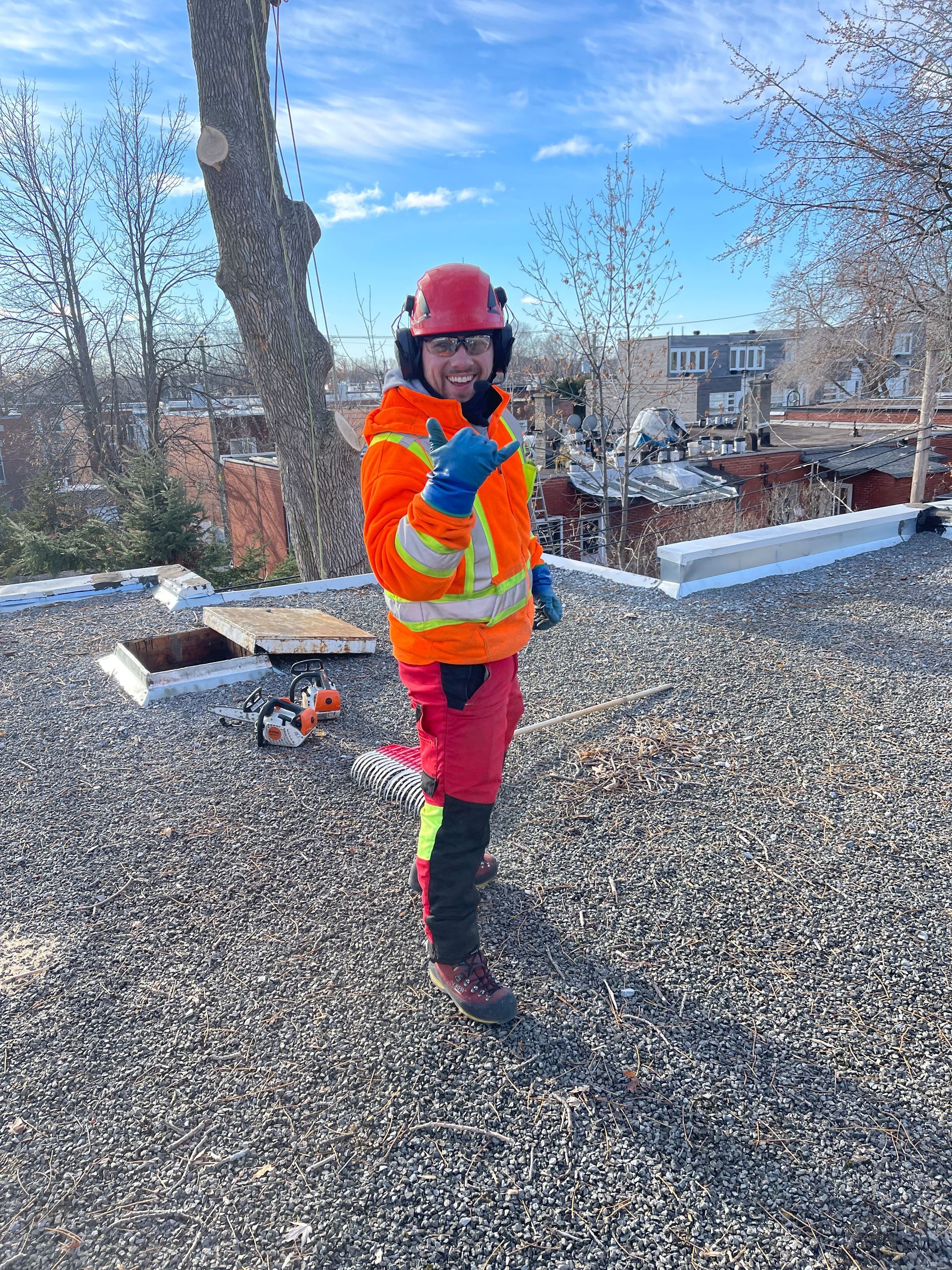 Un homme portant un casque de sécurité se tient debout sur un toit en gravier.