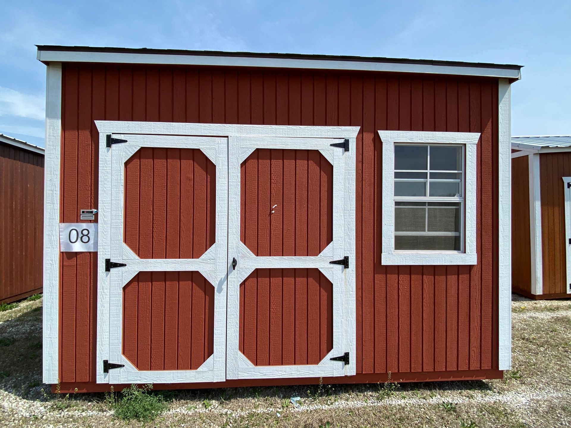 A red shed with white trim and a window.