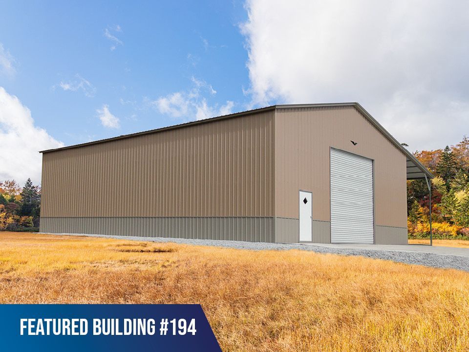 A large metal building is sitting in the middle of a field.