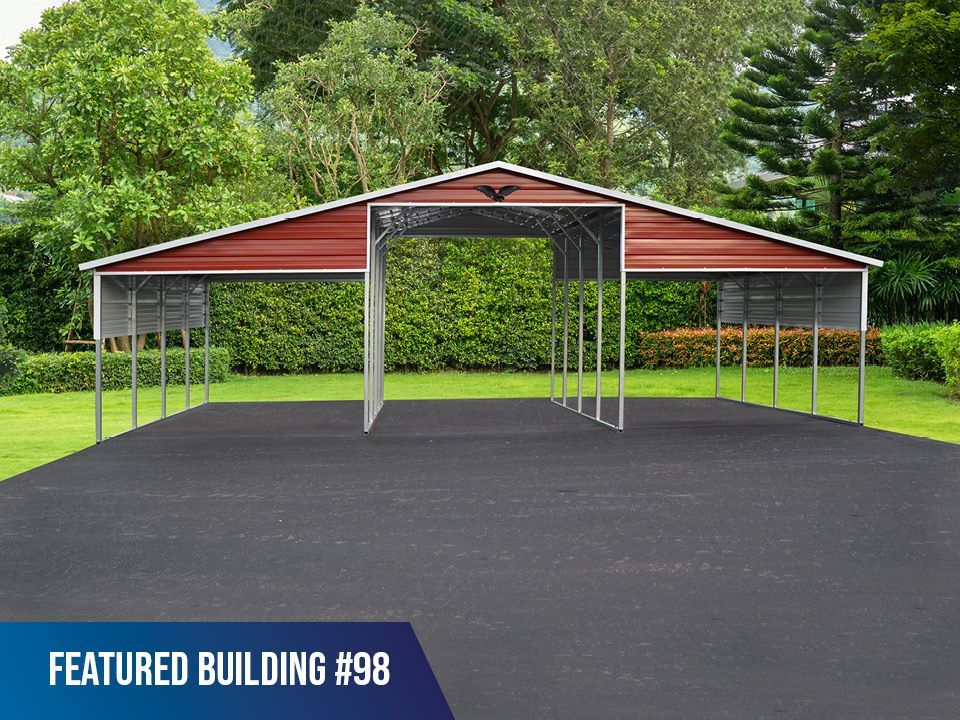 A red and white carport is sitting on top of a black asphalt driveway.