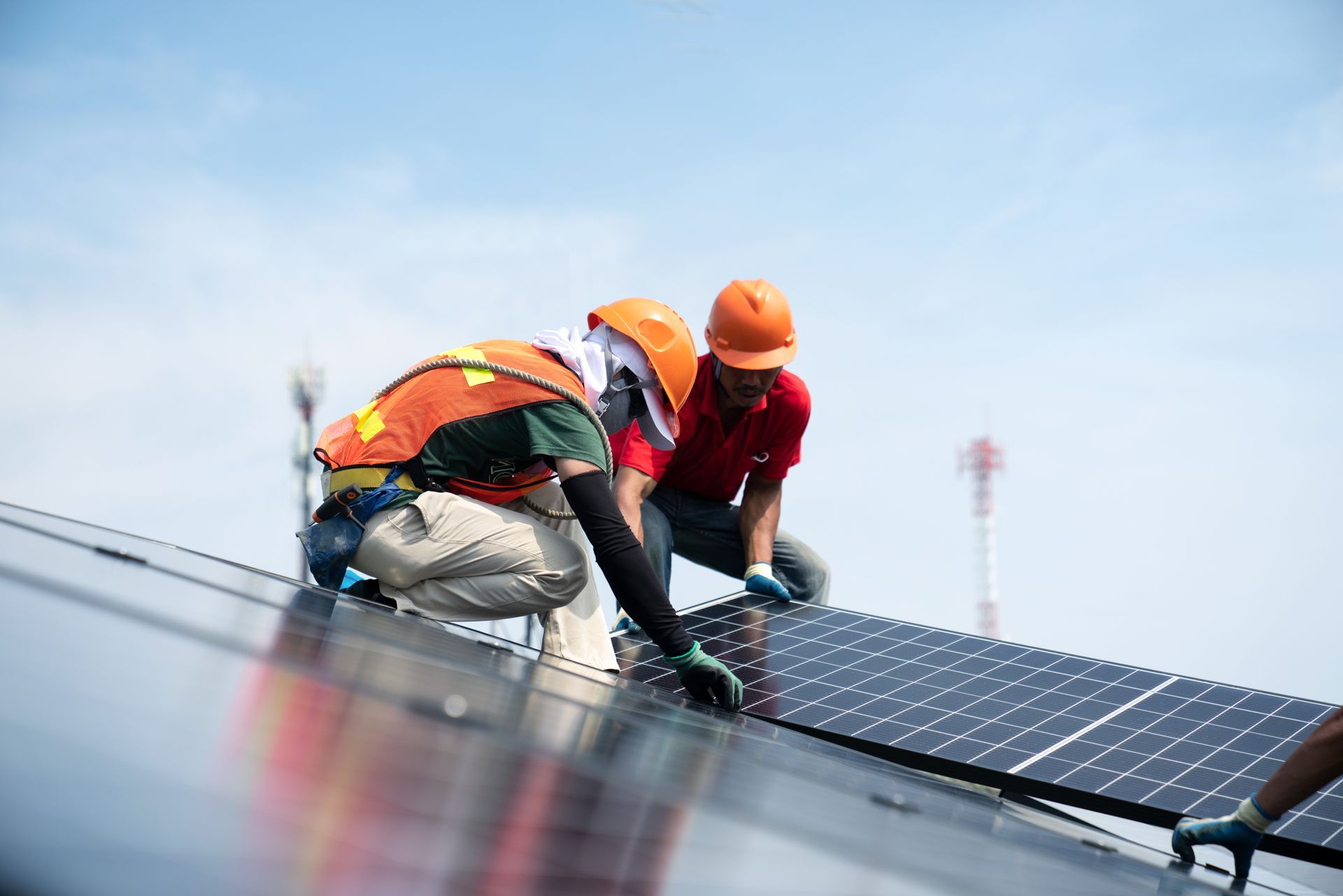Two men are installing solar panels on a roof.