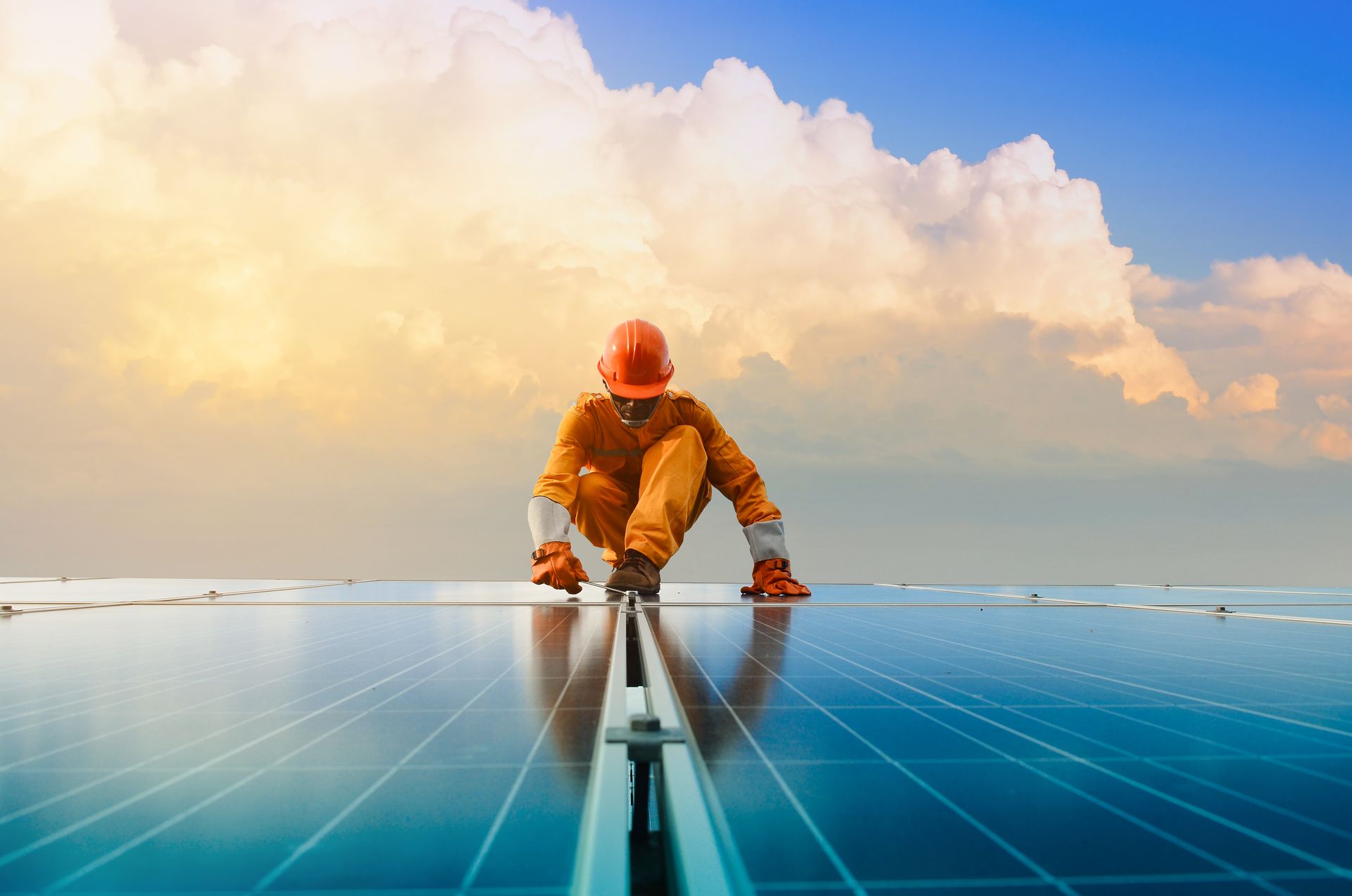 A man is working on a solar panel on top of a building.