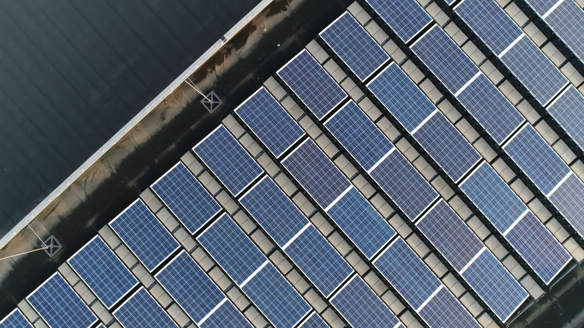 An aerial view of a row of solar panels on a building.
